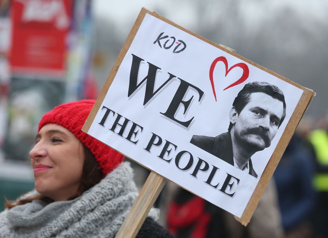 Young woman participating in a pro-democracy march holds a portrait of former Polish President Lech Walesa on February 27, 2016 in Warsaw, Poland.