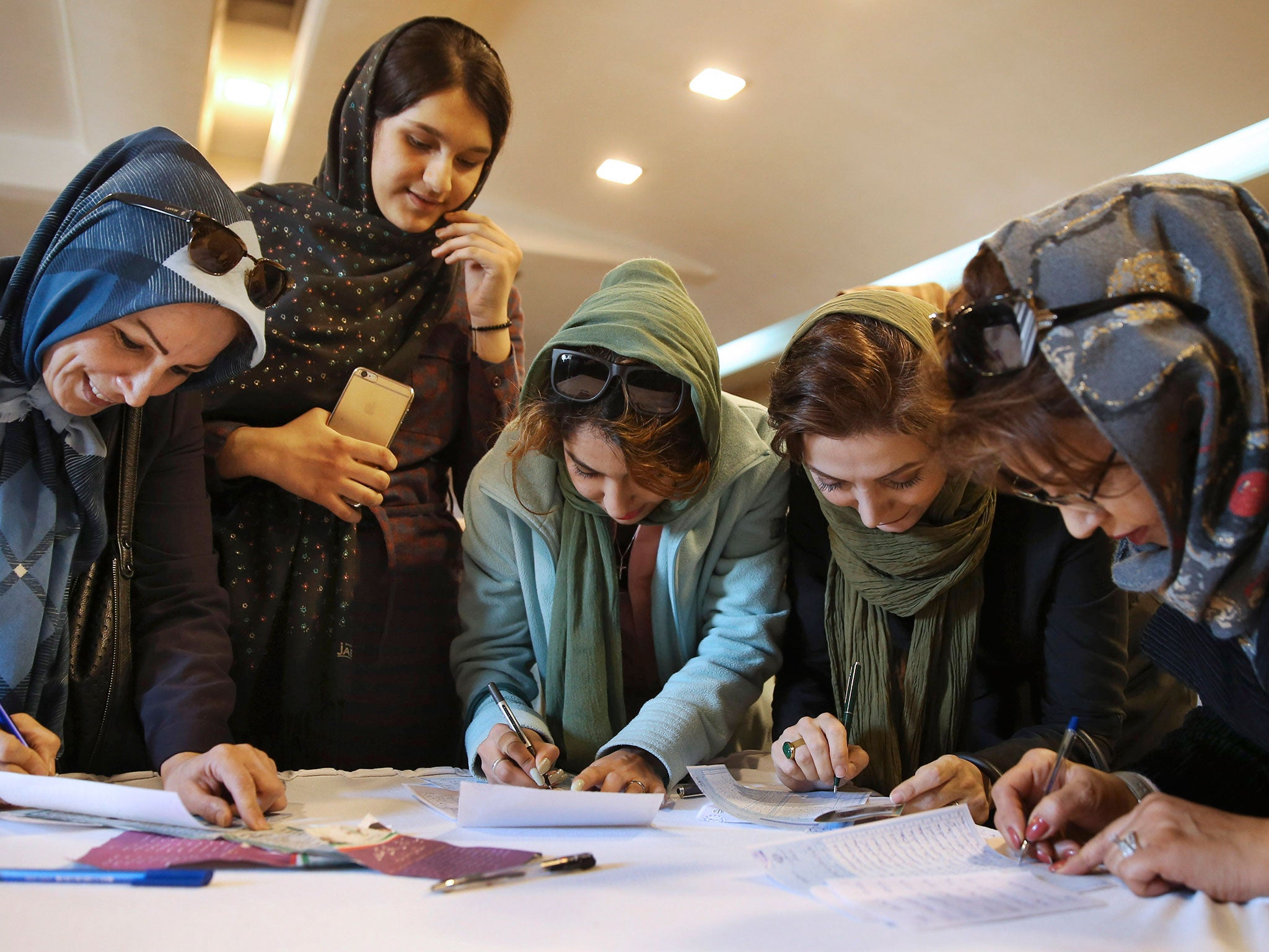 Iranian voters fill out their ballots during the parliamentary and Experts Assembly elections in a polling station in Tehran, Iran