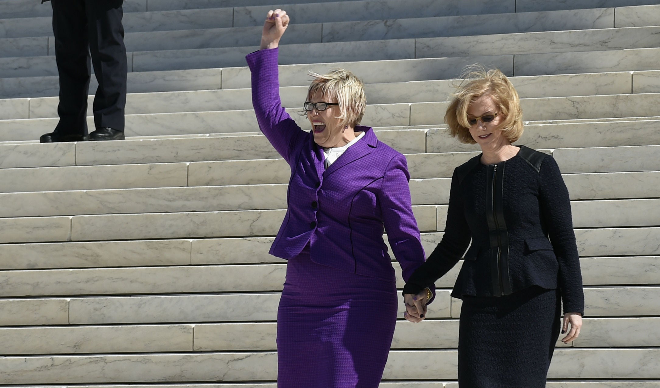 &#13;
Amy Hagstrom Miller raises a hand to pro-choice protestors outside the courthouse&#13;