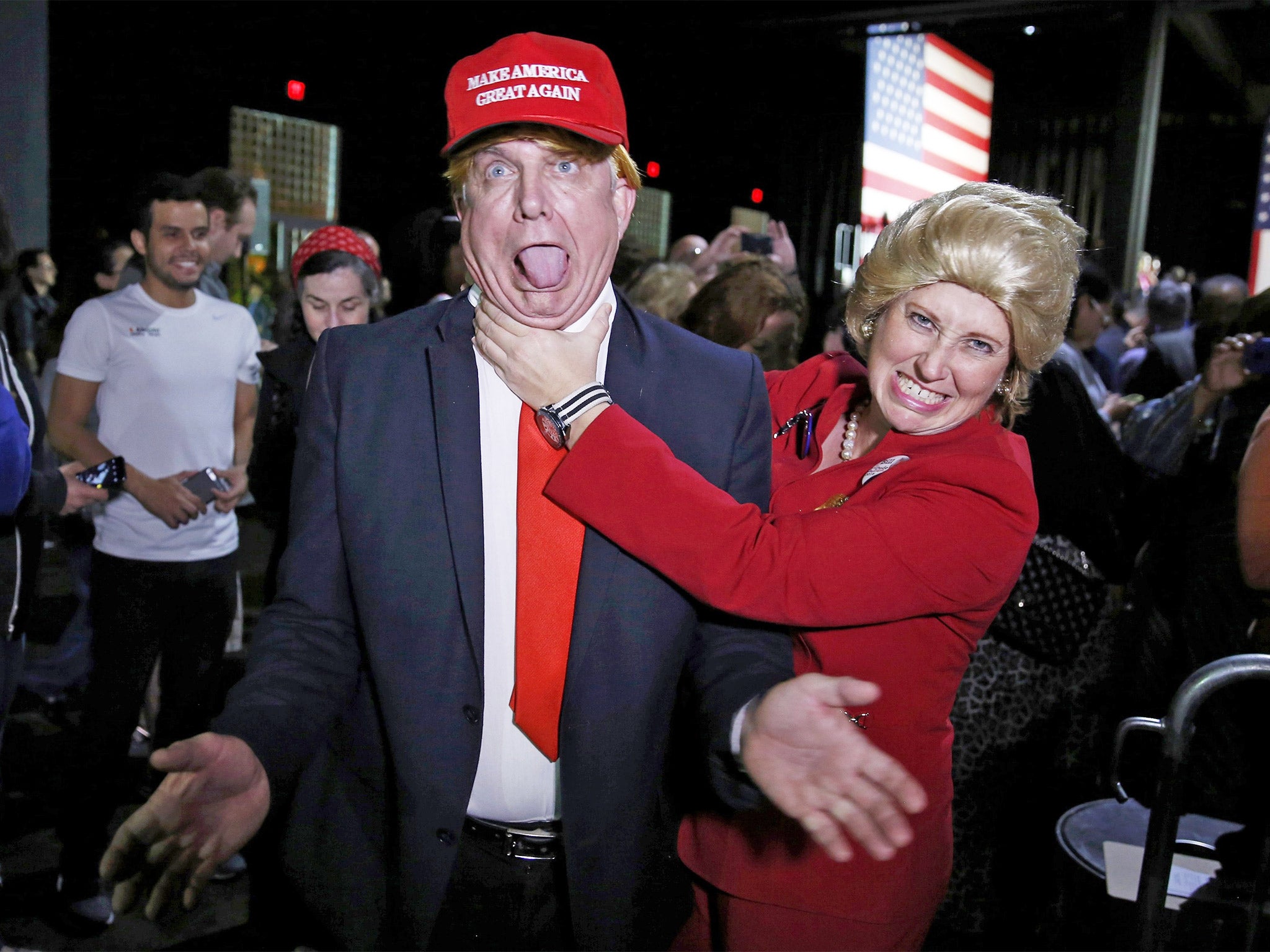 Supporters of Democratic presidential candidate Hillary Clinton take aim at Donald Trump in Miami, Florida, on Super Tuesday