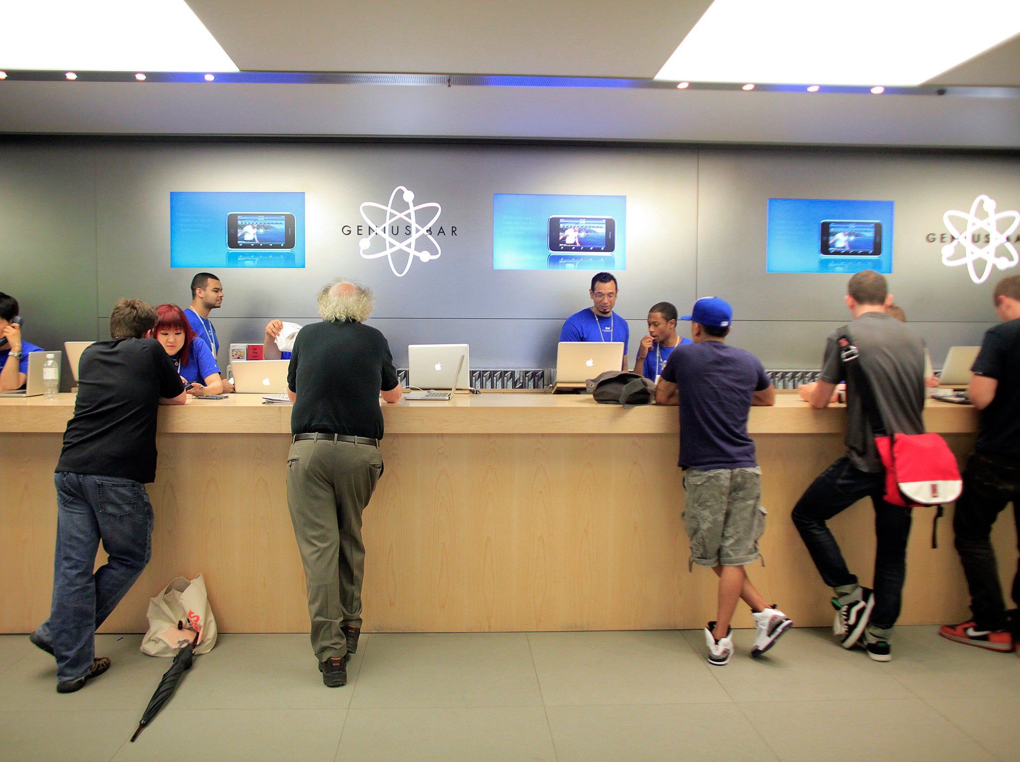 People are served at the Genius Bar at the Apple Store 5th Avenue in New York June 24, 2010