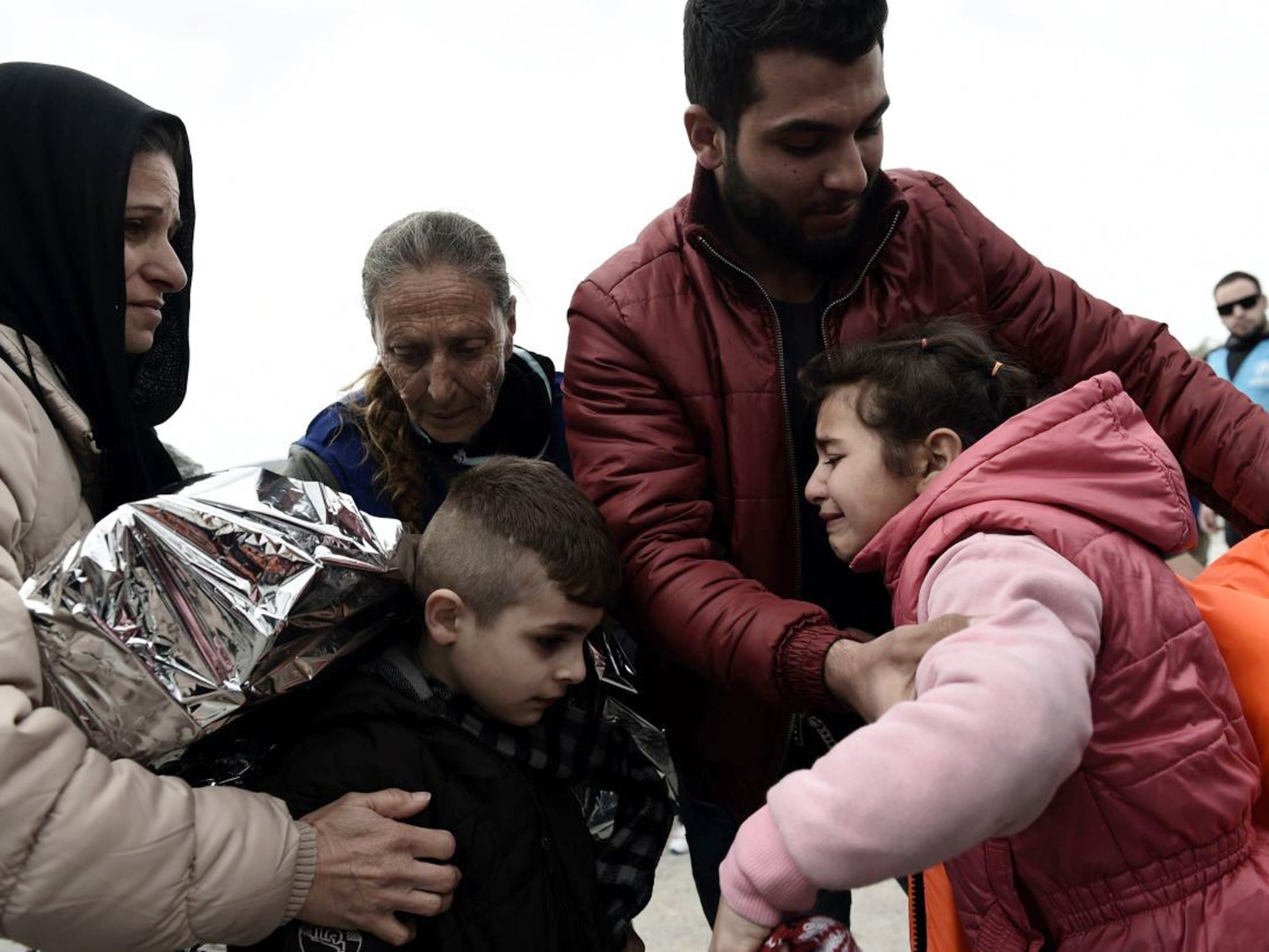 A Syrian Kurdish family from Aleppo embrace as they are reunited after being separated while crossing from Turkey to Greece