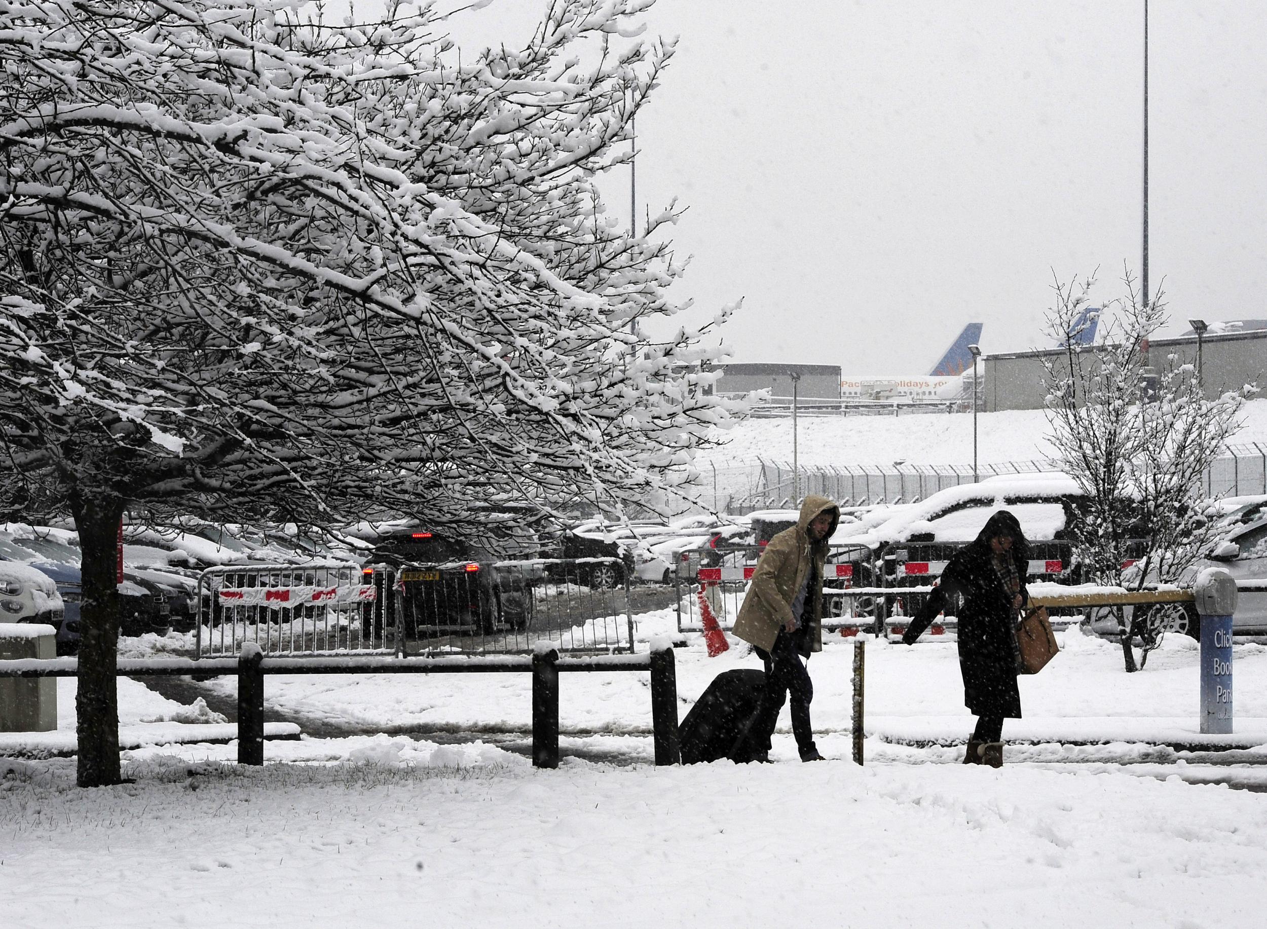 Passengers make their way through the snow to Leeds Bradford Airport which was forced to close while crews worked to clear the runway, as parts of the UK woke up to almost four inches of snow on Friday morning as March continues to feel more like winter than spring.