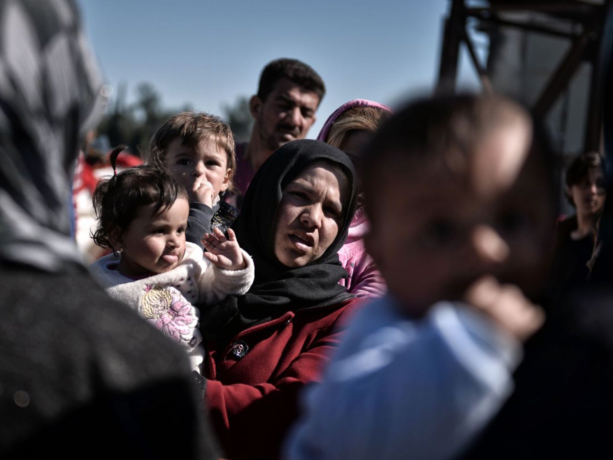 A mother and her child with aid workers in Idomeni