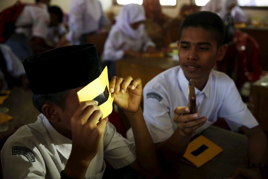 Schoolchildren test their eclipse glasses in Ternate island (Pic: Beawiharta/Reuters)