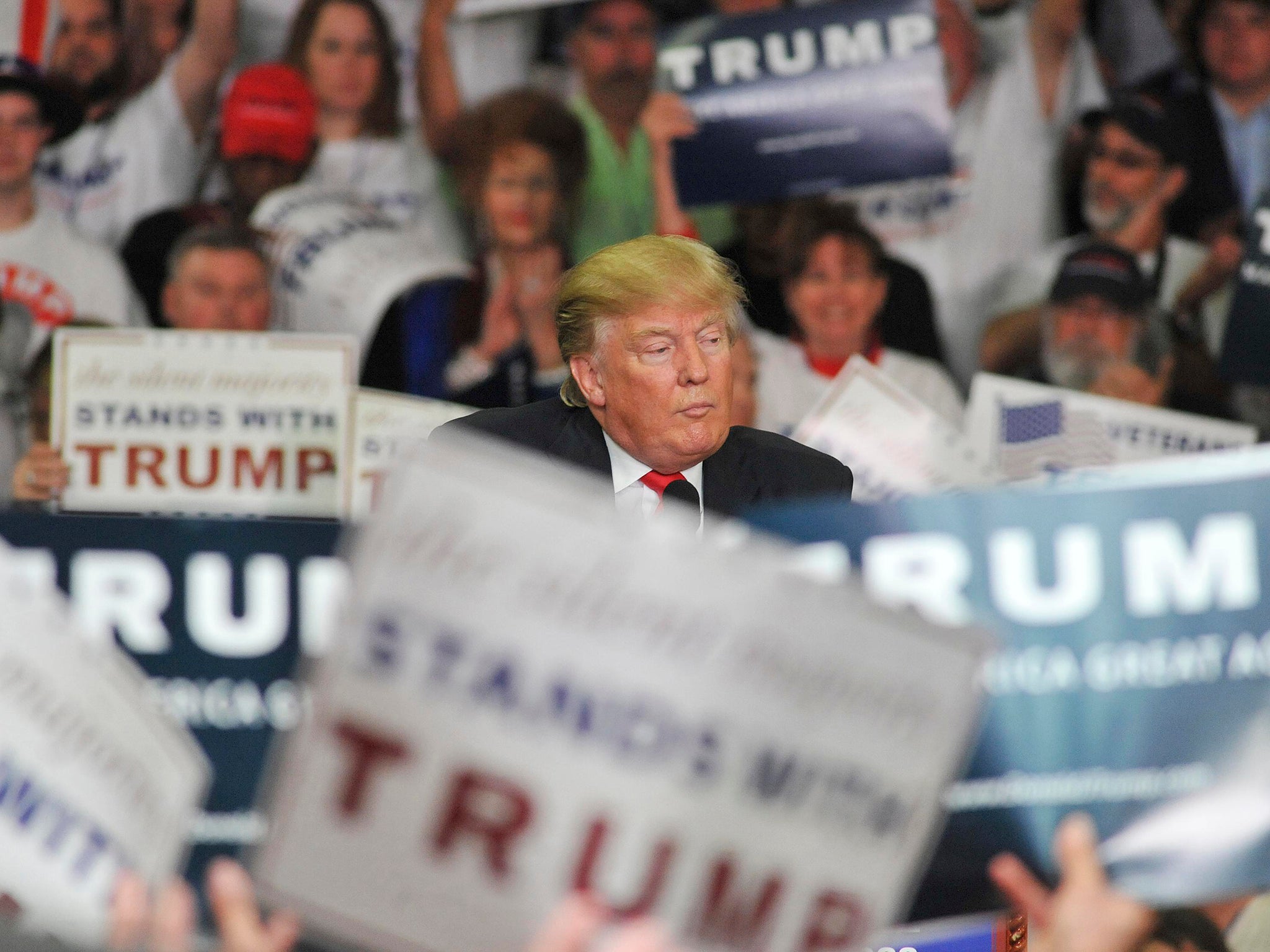 Donald Trumps is surrounded by signs of supporters as he speaks at Madison Central High School during at a campaign rally in Madison, Mississippi.