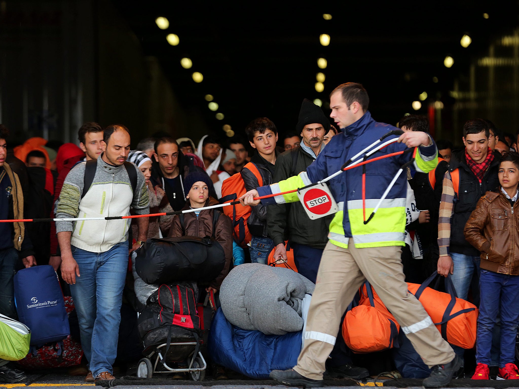 Refugees wait to disembark from a ferry coming from the Greek islands of the north-eastern Aegean sea in the port of Piraeus, near Athens, Greece