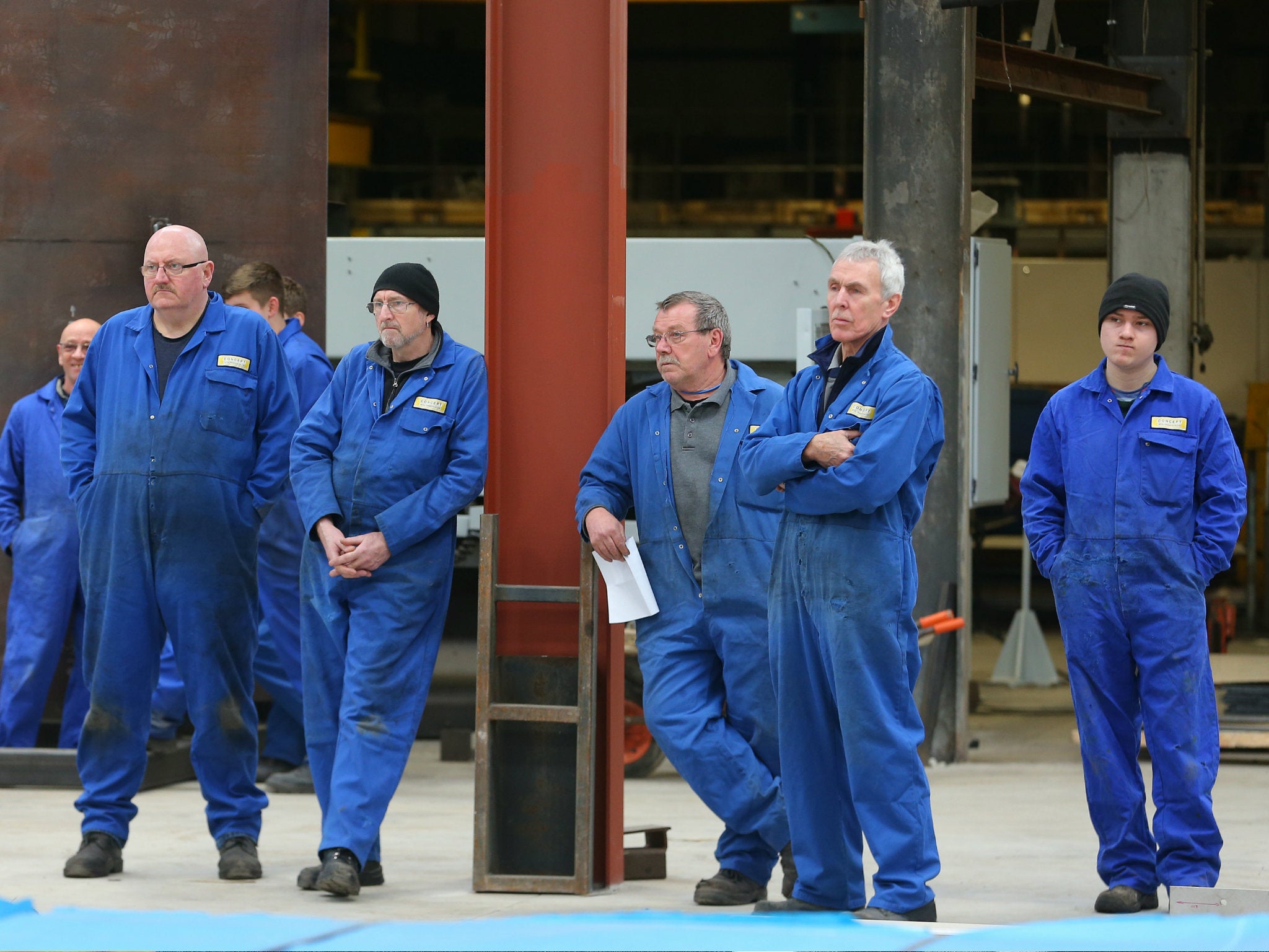 Members of staff listen as UKIP Leader Nigel Farage addresses an invited audience during a visit to a Manchester metal works on March 23, 2015