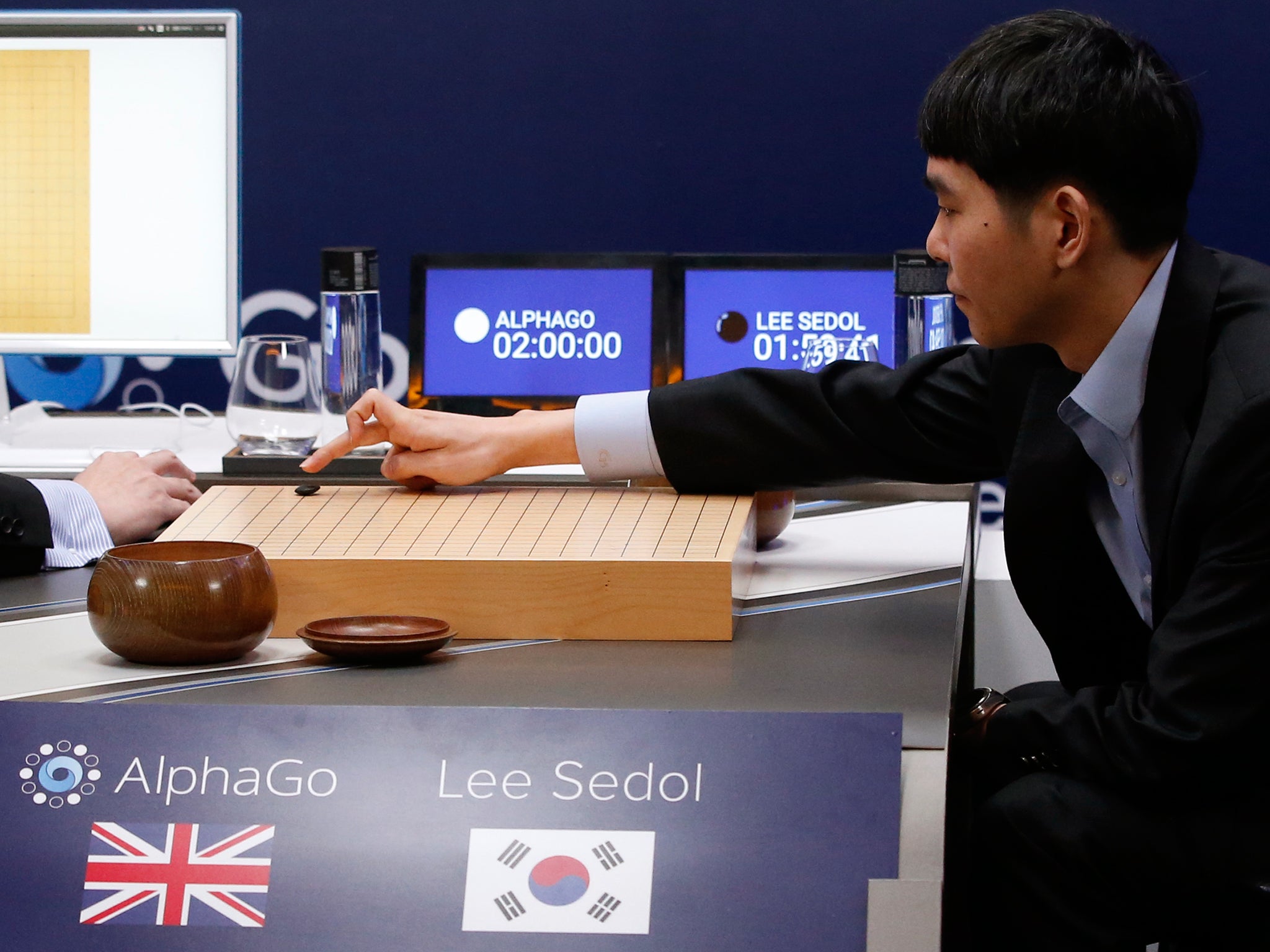 South Korean professional Go player Lee Sedol, right, puts the first stone against Google's artificial intelligence program, AlphaGo, during the Google DeepMind Challenge Match in Seoul, South Korea