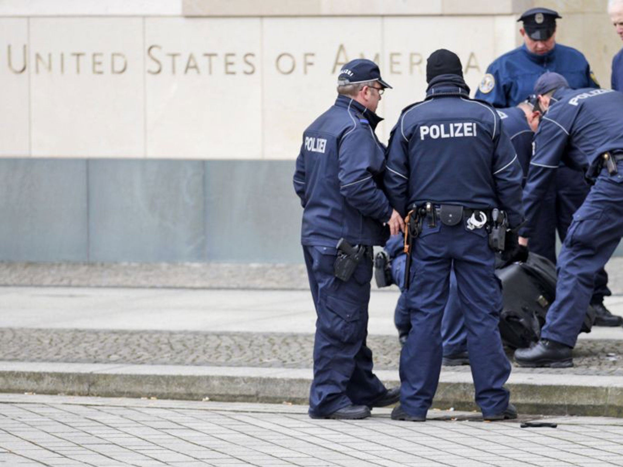 Police officers examine a suitcase in front of the US embassy in Berlin, Germany, Friday, March 11, 2016.