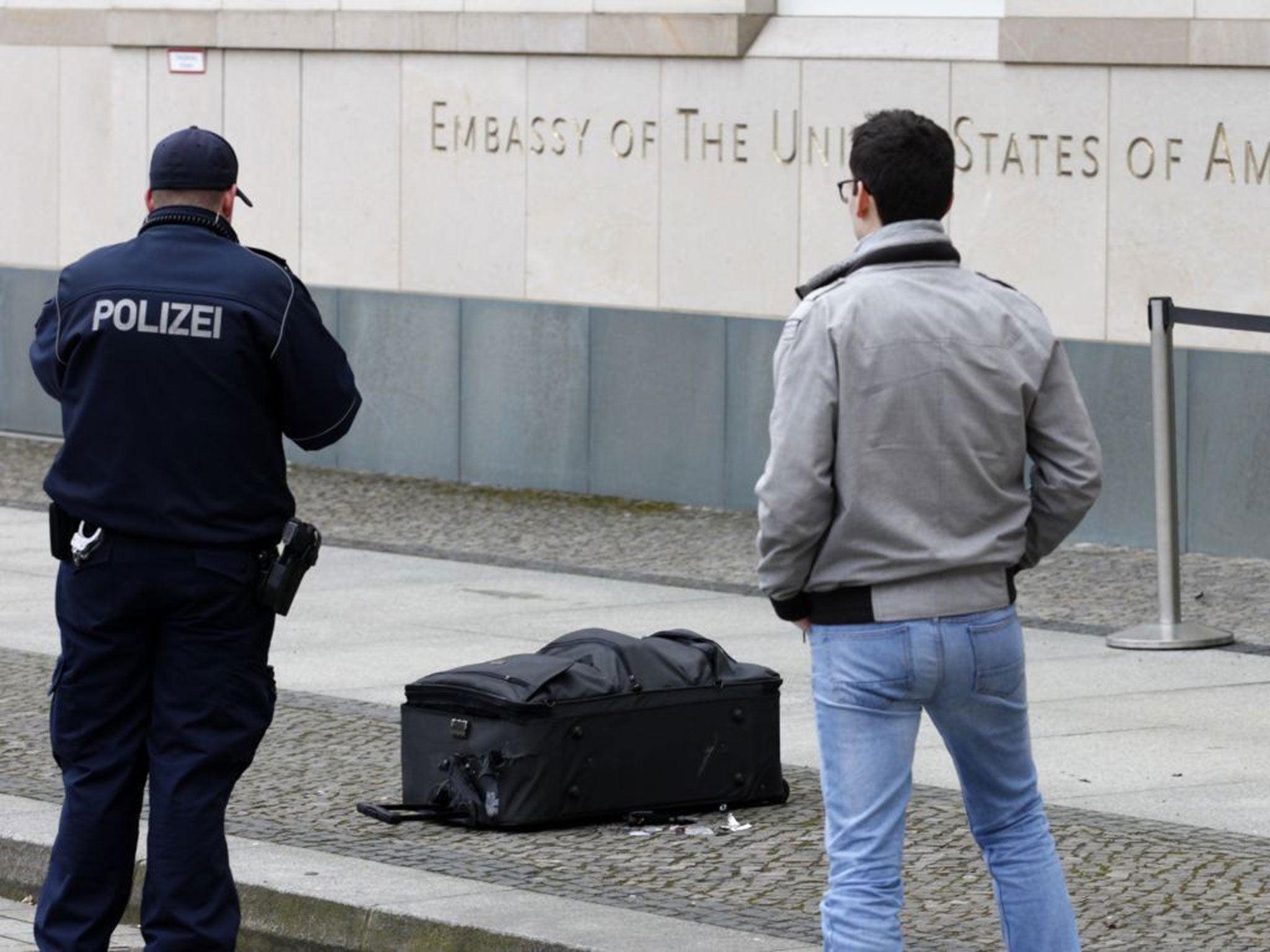 Police officers photograph a suitcase in front of the US embassy in Berlin, Germany, Friday, March 11, 2016.