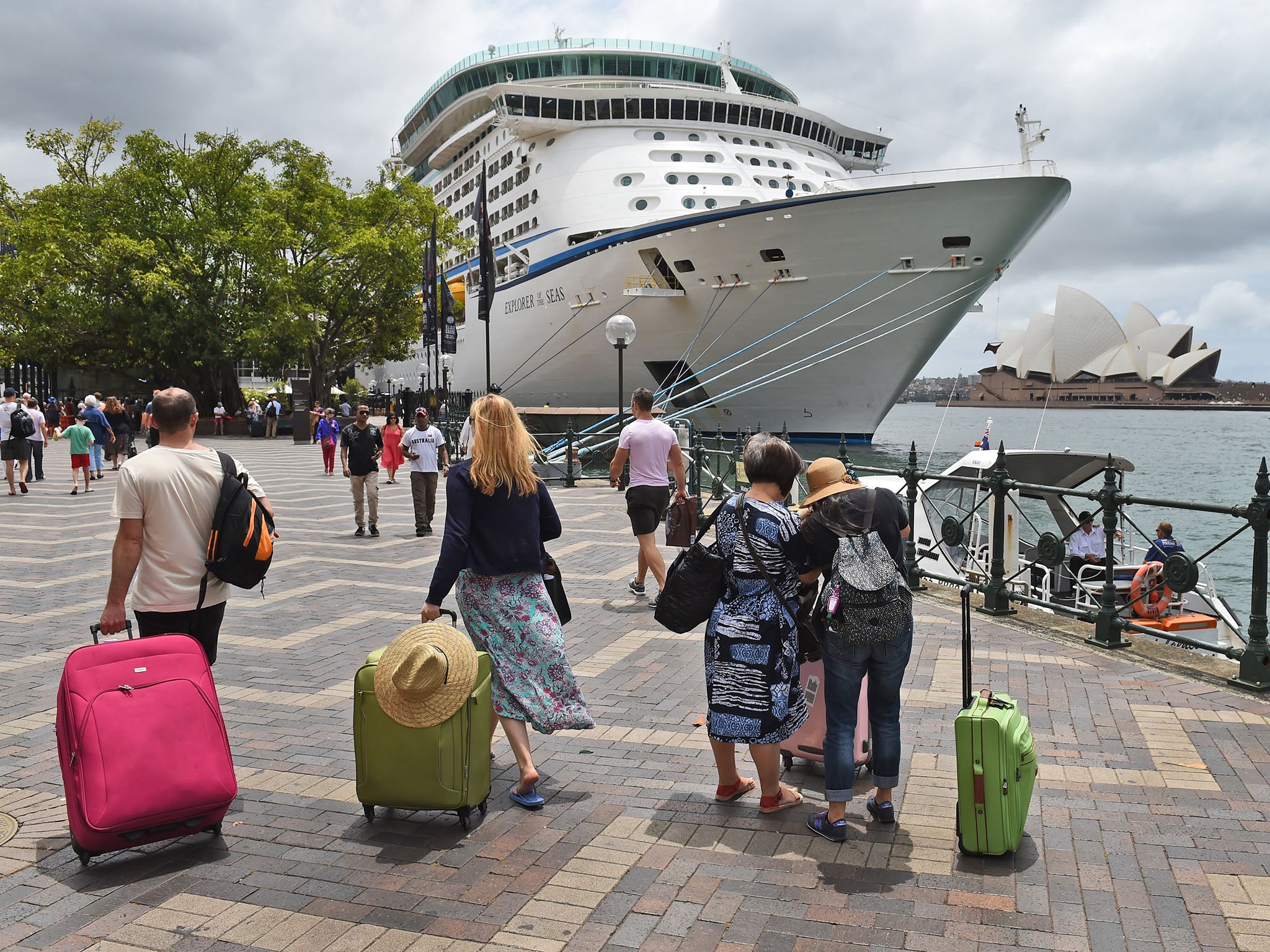 Holiday-makers walk towards their cruise ship in Sydney's Circular Quay.