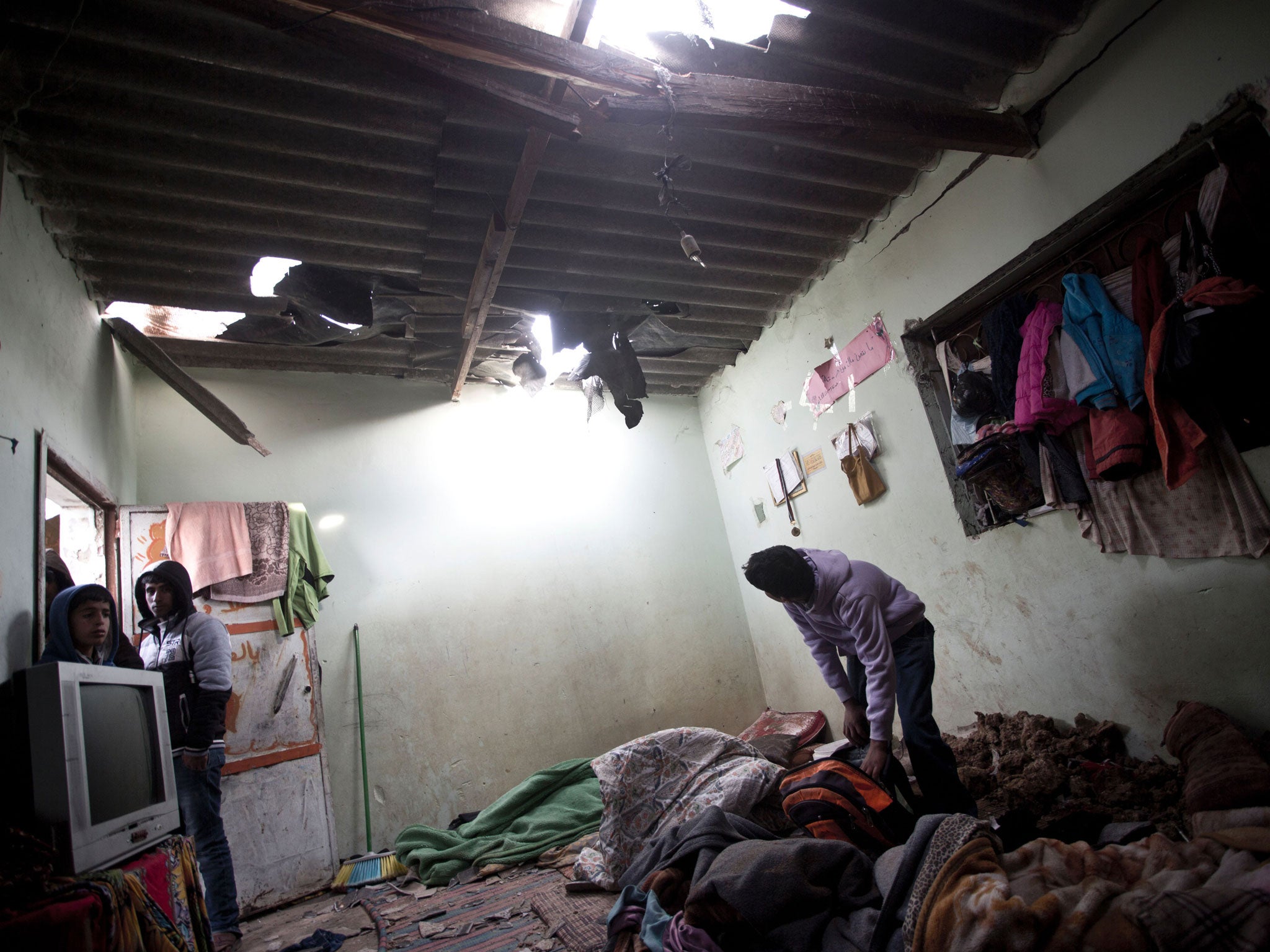 A Palestinian boy inspects a bedroom of the damaged Khoussa family home after an Israeli strike on Hamas bases in Beit Lahiya, northern Gaza strip