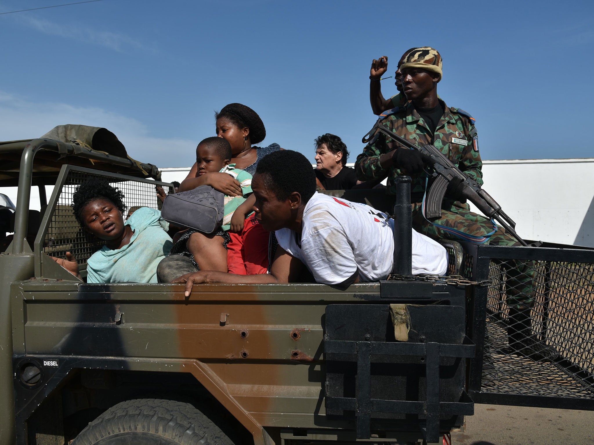 Ivorian security forces evacuate people after heavily armed gunmen opened fire on March 13, 2016 at a hotel in the Ivory Coast beach resort of Grand-Bassam