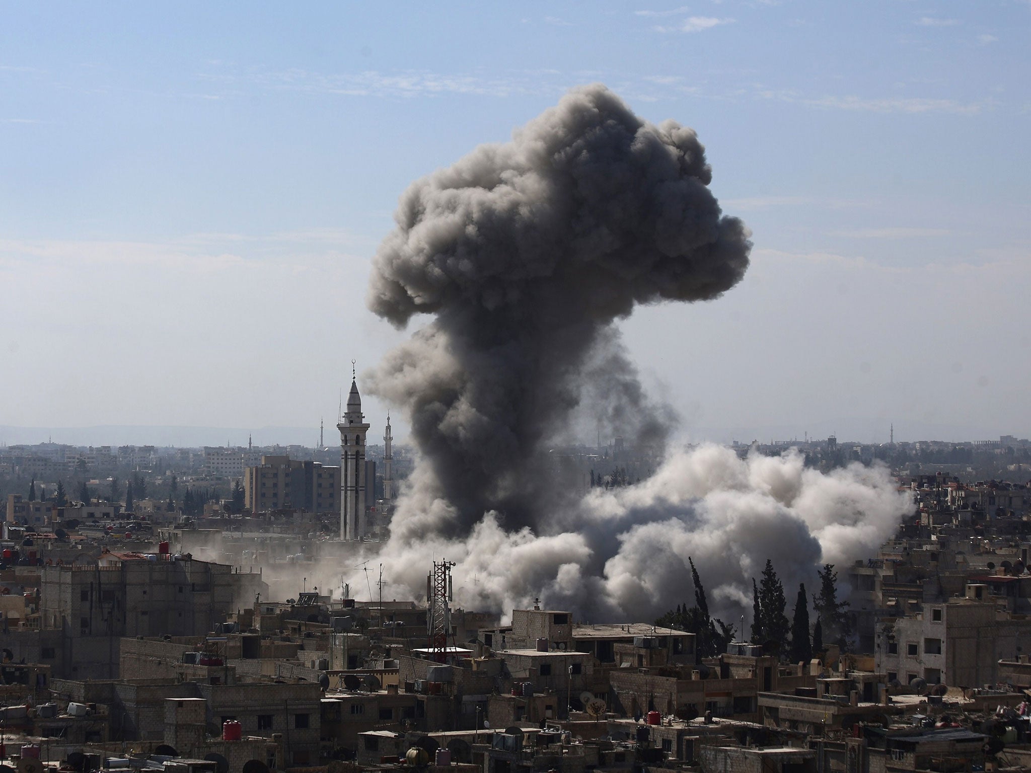 A cloud of smoke rises following an air strike by Syrian government forces in the rebel-held area of Douma, north east of the capital Damascus