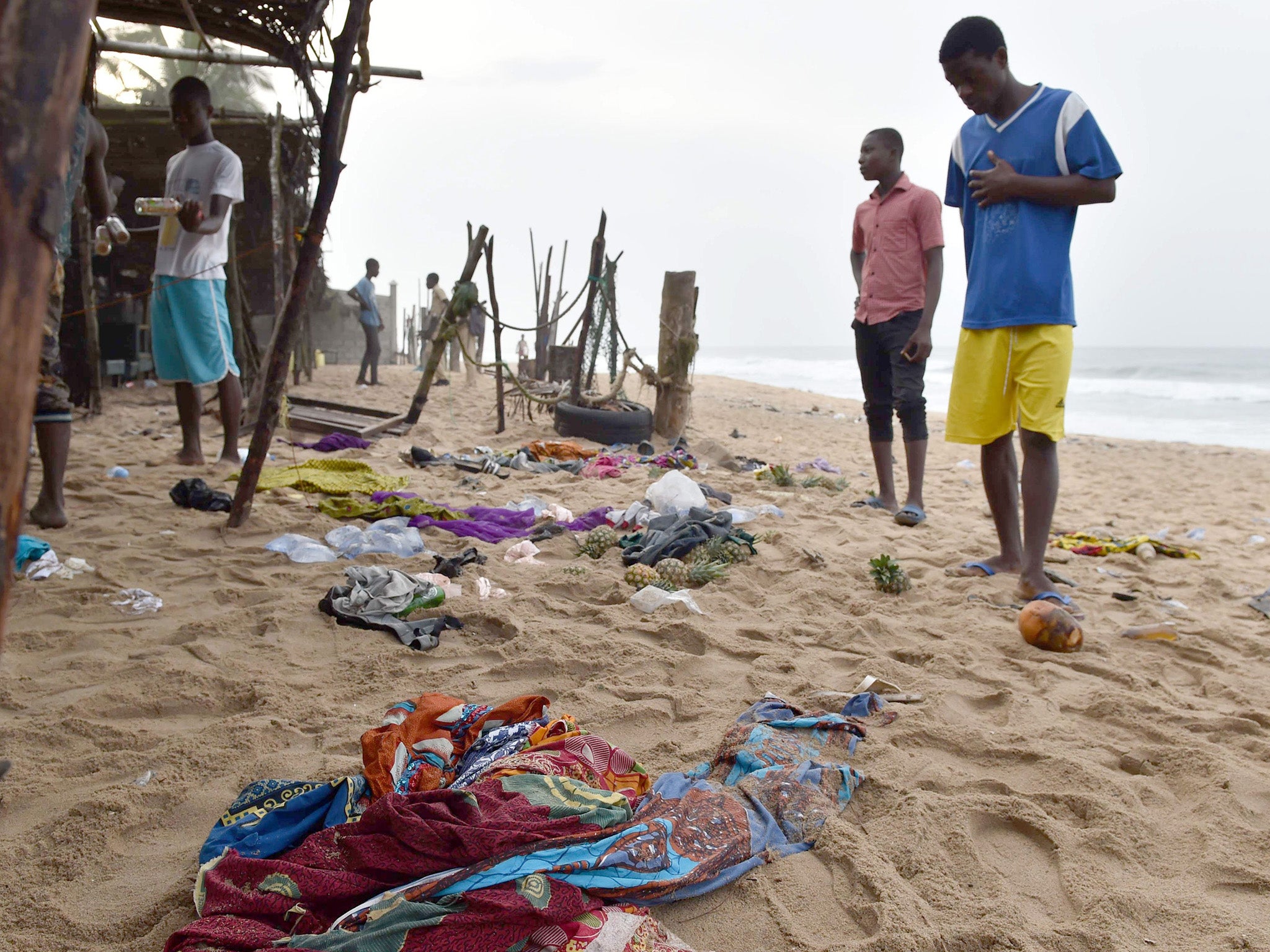 Locals look at the belongings left behind by people who fled the gunman in Grand Bassam