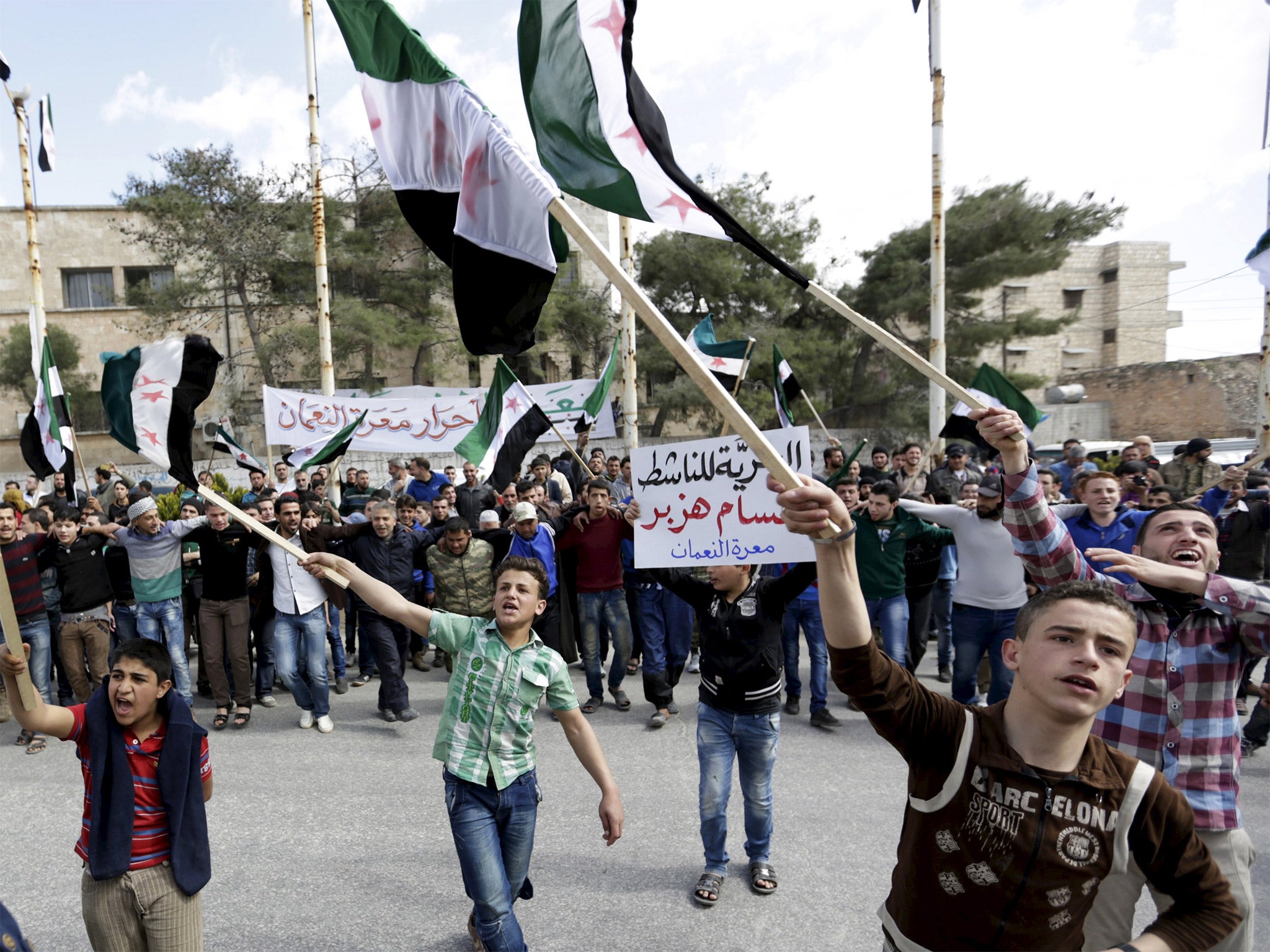 Young supporters of the Free Syria Army flags wave flags in the town of Marat Numan, Idlib province