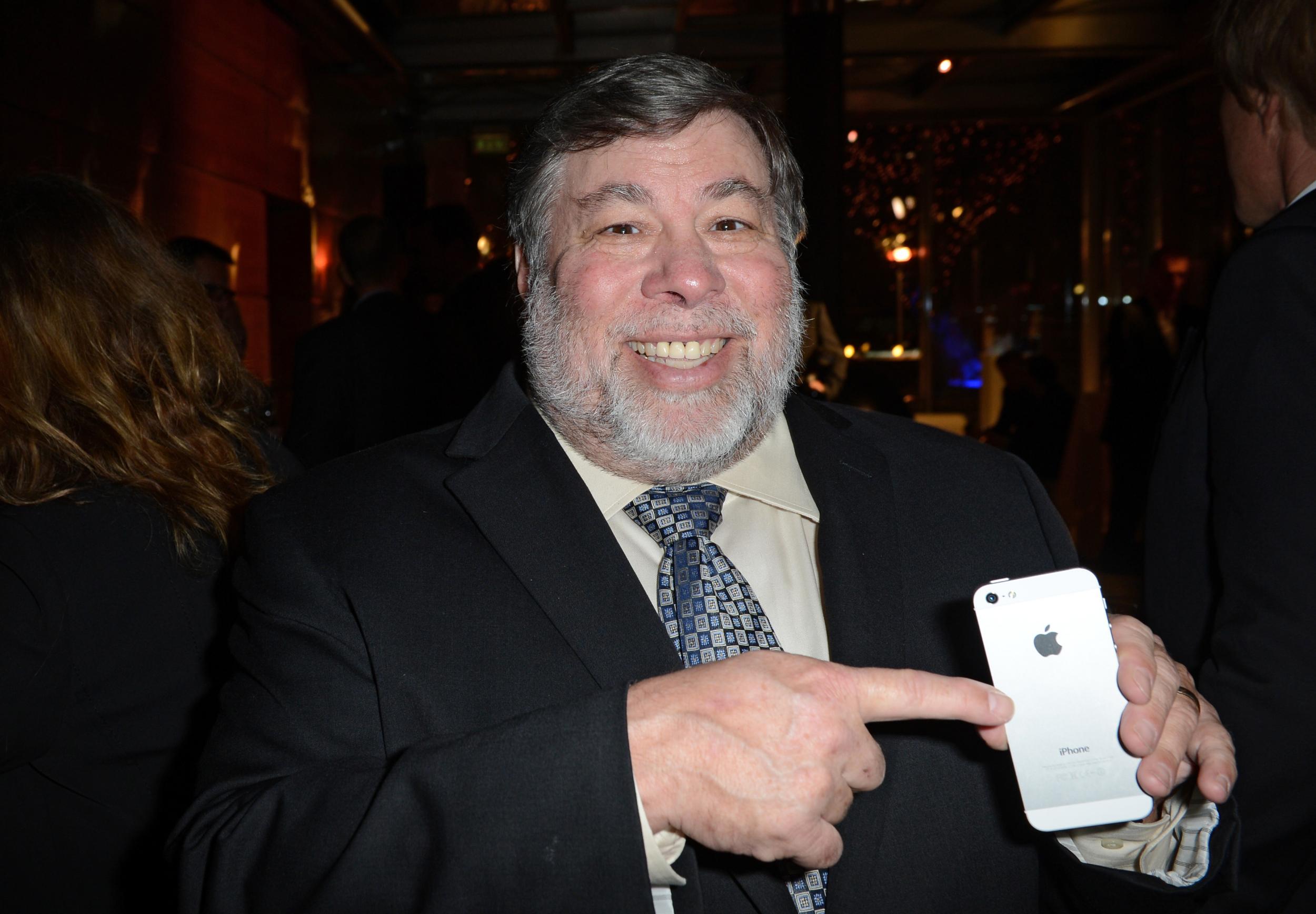 Steve Wozniak poses with an iPhone in 2013