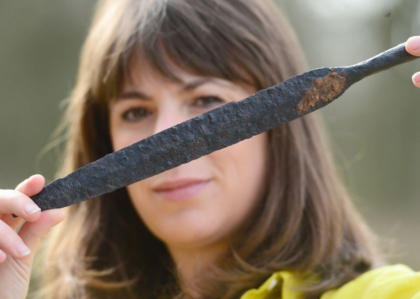 MAP Archaeological Practice employee Sophie Coy holds a spear head found at the site (Pic: PA)