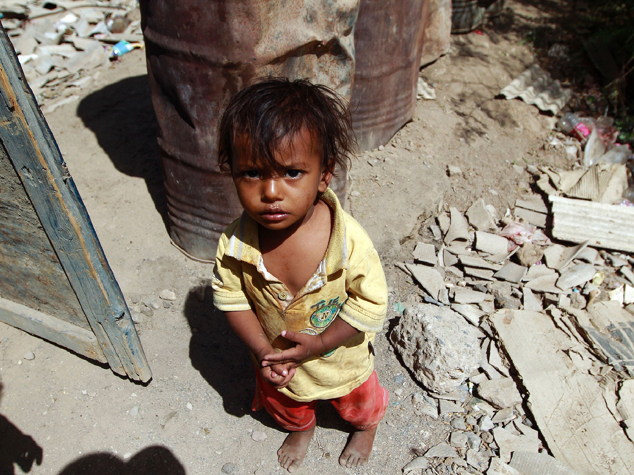 A Yemeni child stands outside the family house which was destroyed several months ago in an air-strike by the Saudi-led coalition at a slum in the capital Sanaa