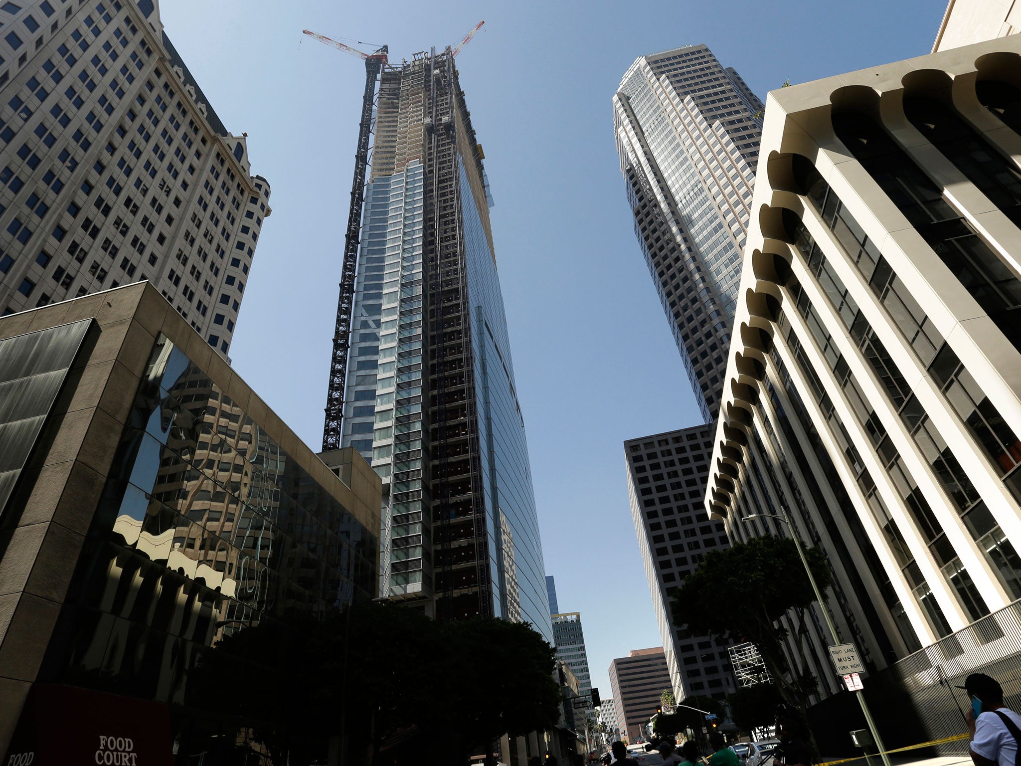 Passerby's look up at the Wilshire Grand Tower on South Figueroa Street where a worker fell to his death on Thursday, 17 March, 2016