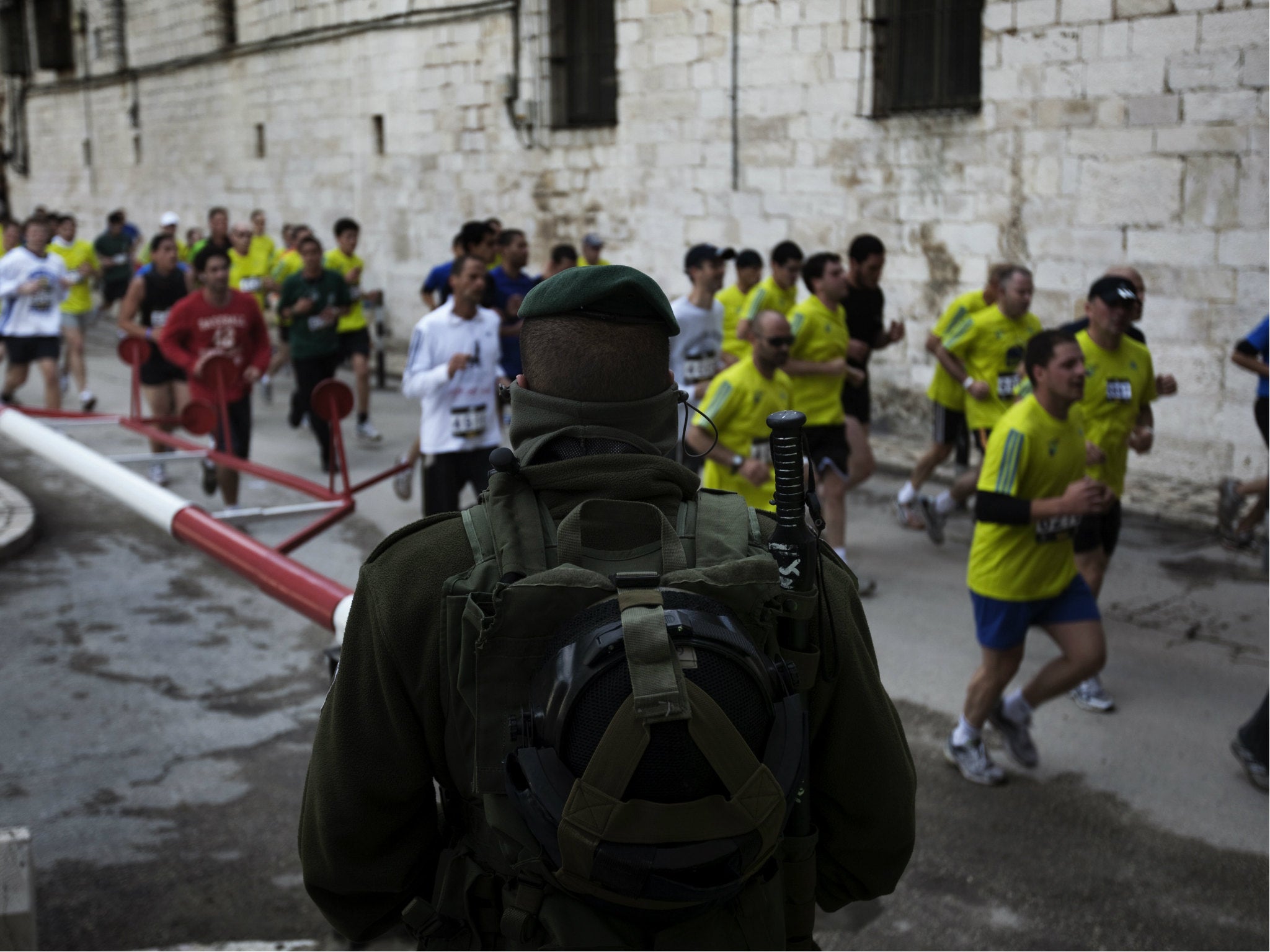 Israeli forces keep watch as foreigners and Israelis run through Jerusalem's Old City during Jerusalem's first-ever marathon on March 25, 2011