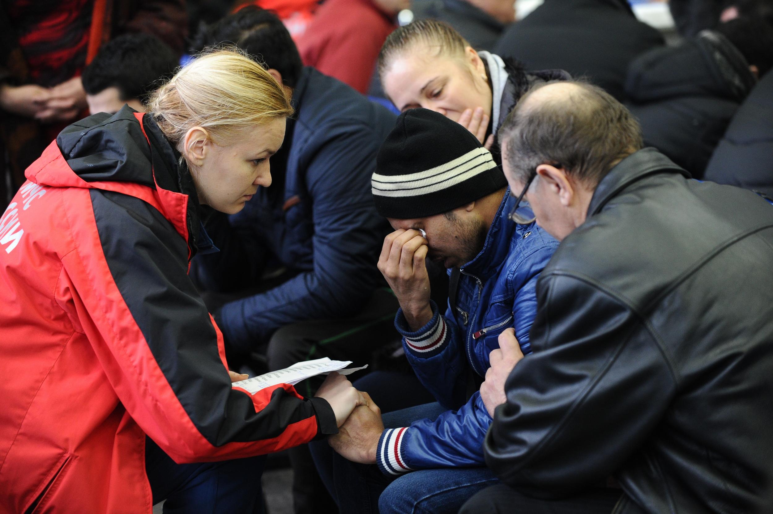 A Russian Emergency Situations Ministry employee, left, tries to comfort a relative of the plane crash victims at the Rostov-on-Don airport