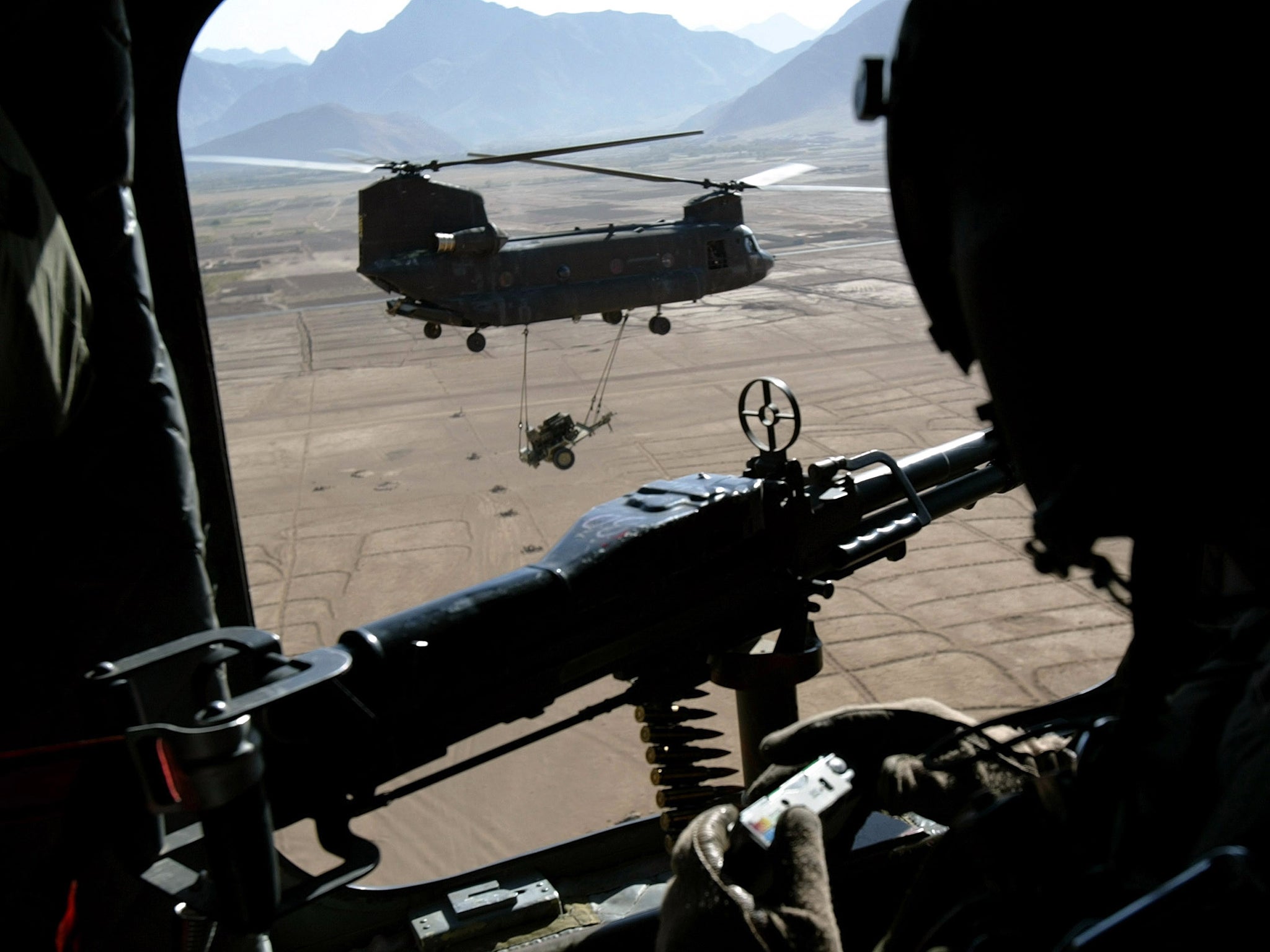 Inhospitable terrain: flying from the Shkin firebase, a US Army Chinook helicopter transports a generator into the warzone of Paktika Province.