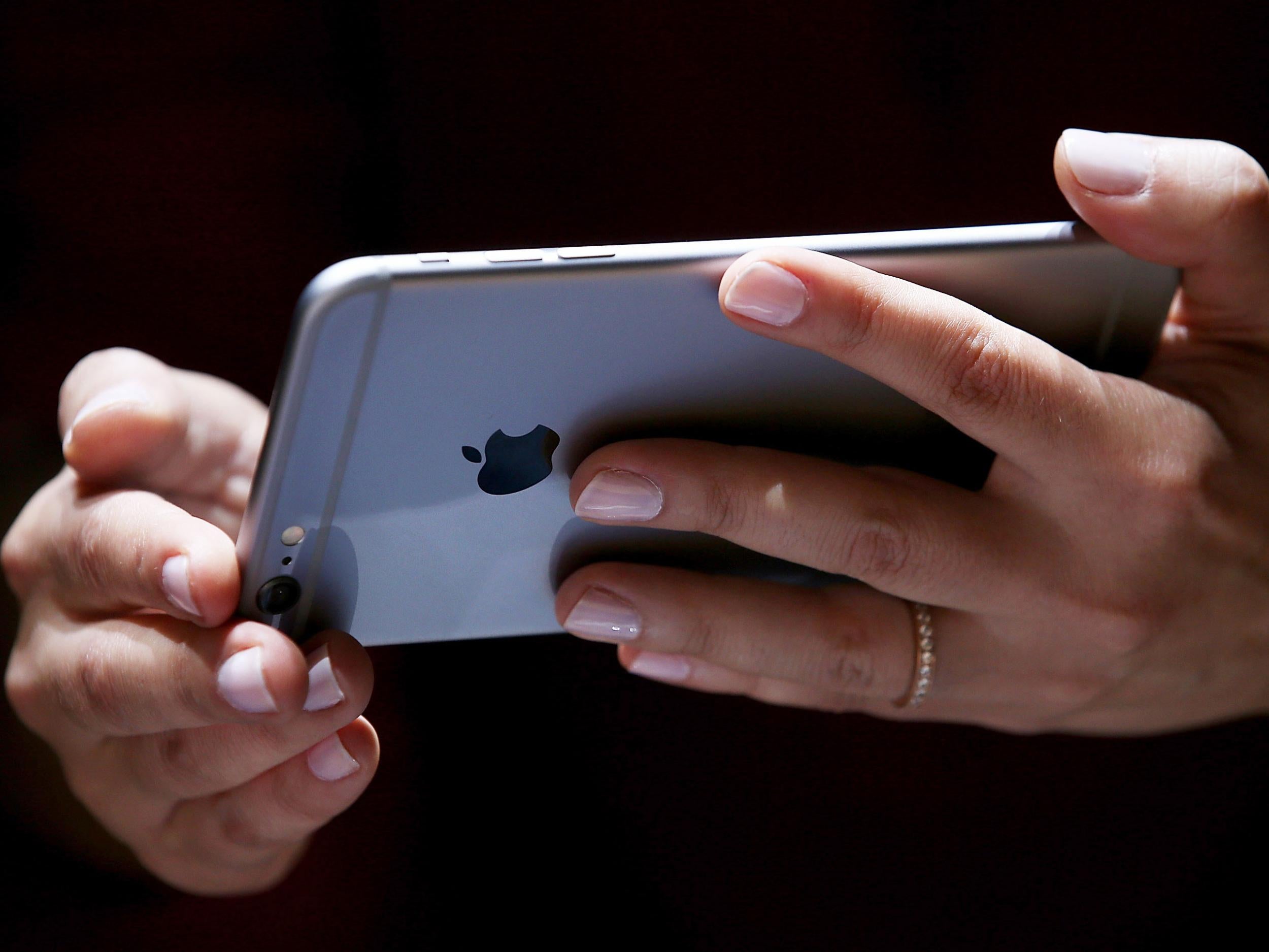 A woman holds an iPhone 6 at an Apple launch event in 2014