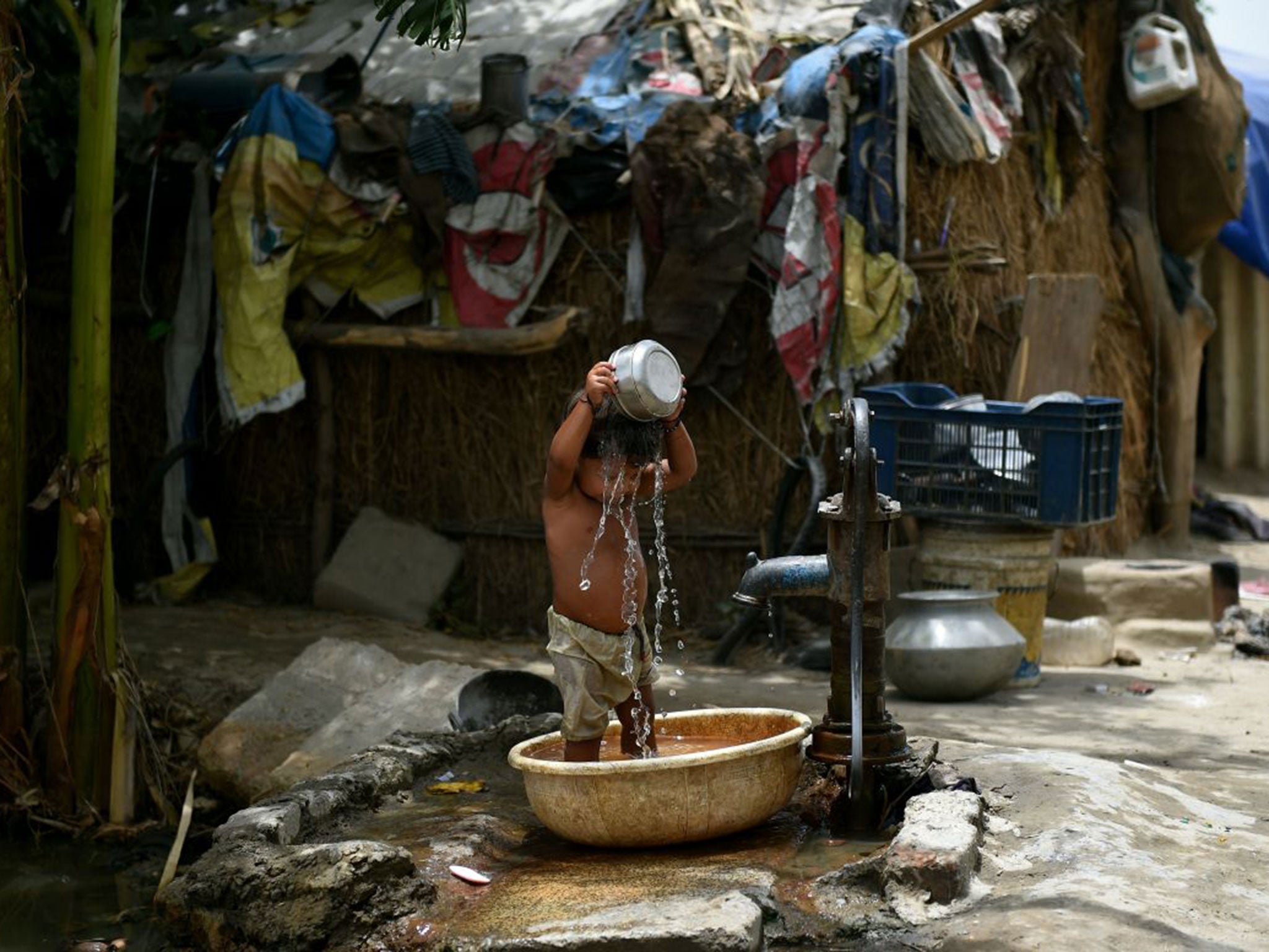 A young Indian boy attempts to cool himself off in Delhi