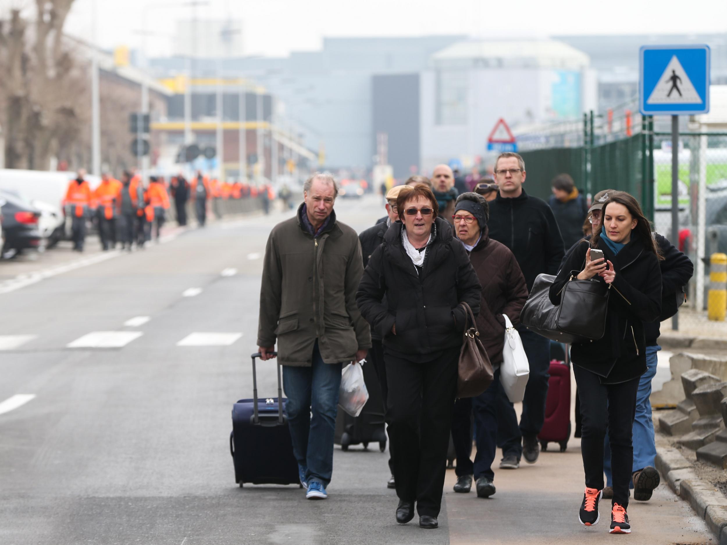 People are evacuated from Brussels Airport, in Zaventem, on March 22, 2016. after at least 13 people have been killed by two explosions in the departure hall of Brussels Airport