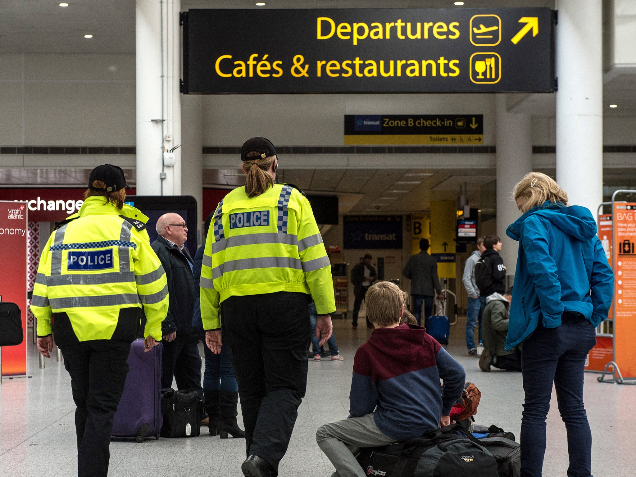 Police officers patrol Gatwick Aiport's south terminal shortly after the Brussels attacks