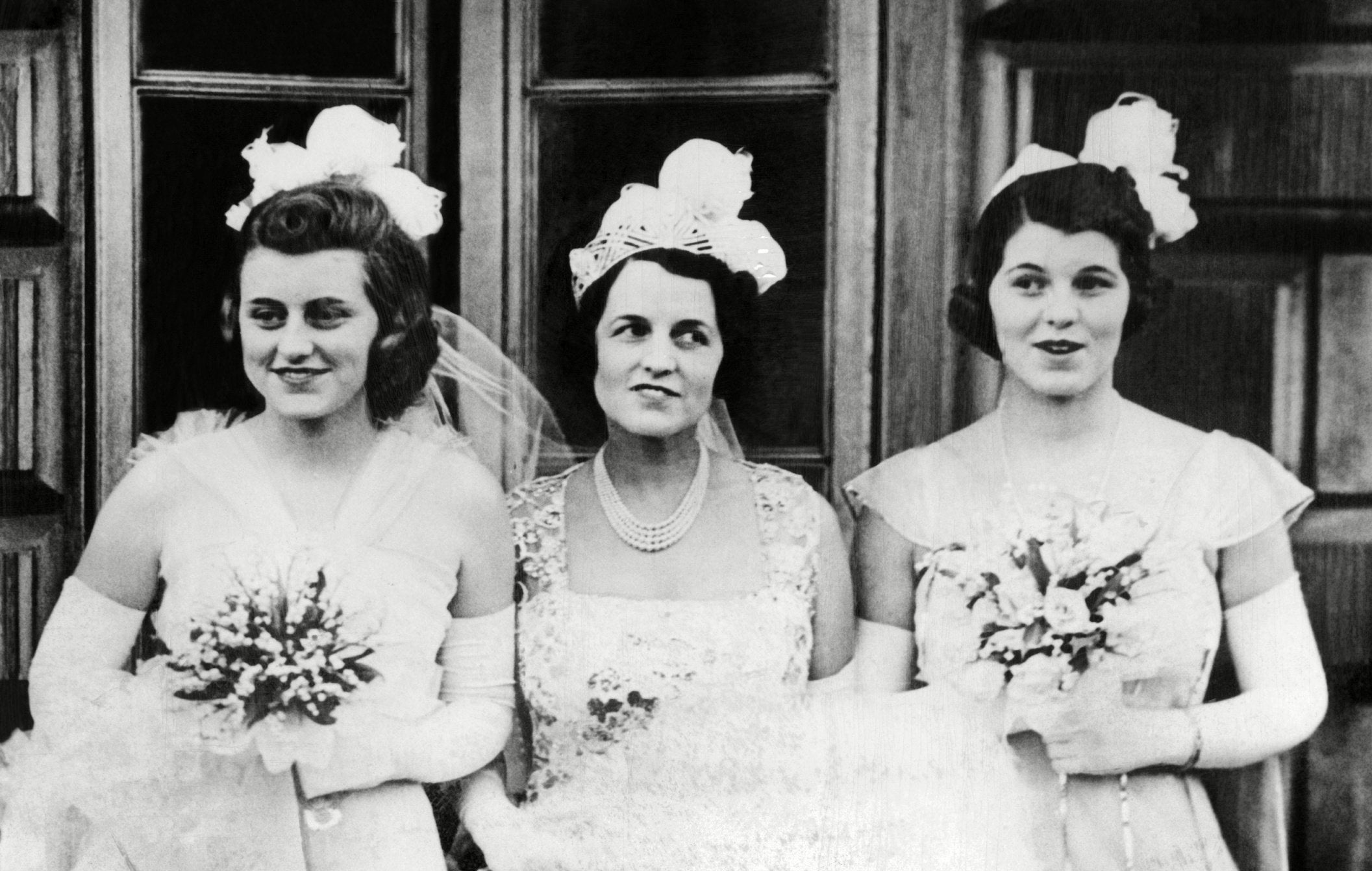 Kathleen, Rose, and Rosemary Kennedy, in formal gowns and with bouquets for their presentation at Buckingham Palace. May 11, 1938.
