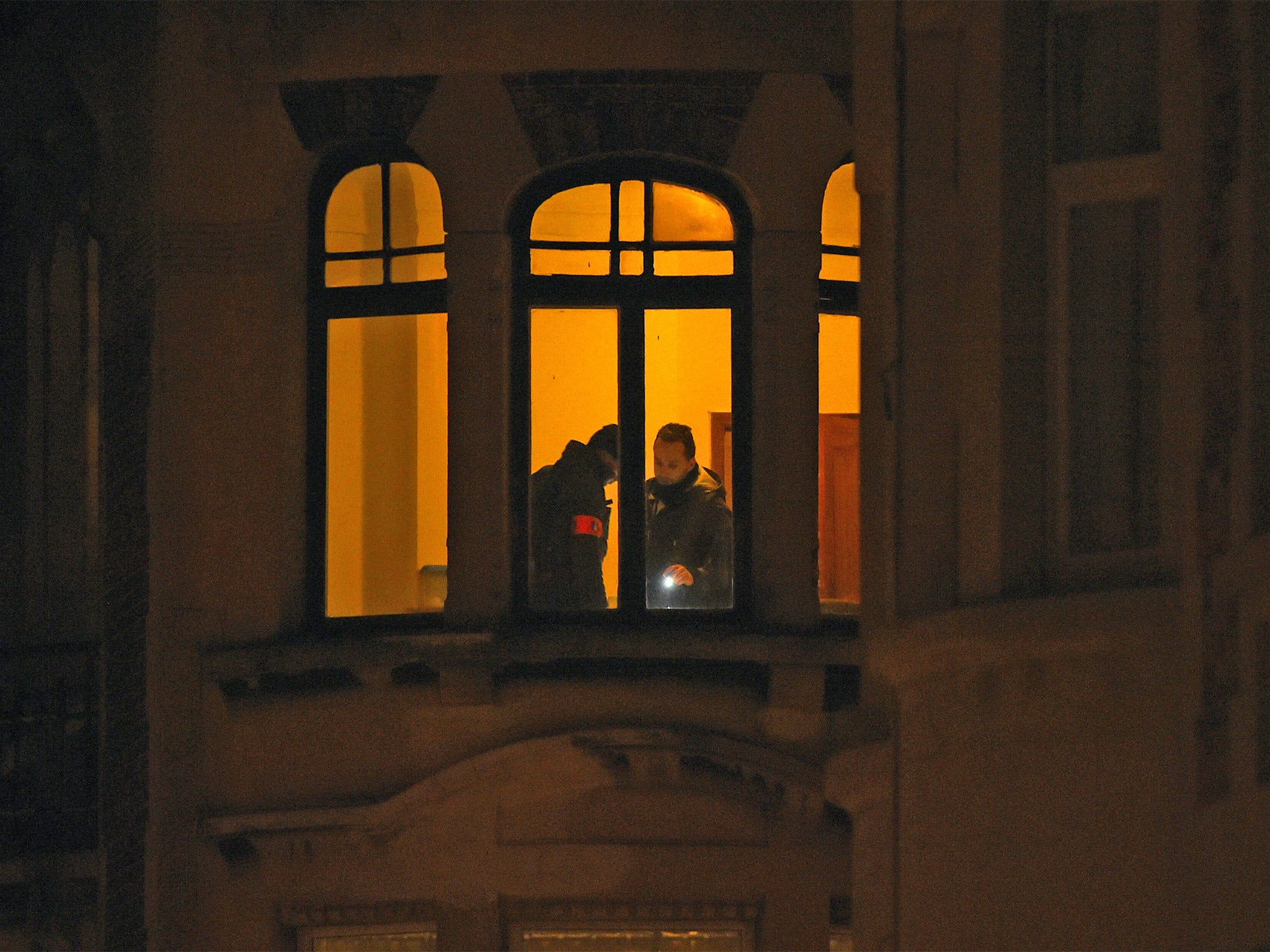 Police officers carry out searches in a building in Schaerbeek (Getty)