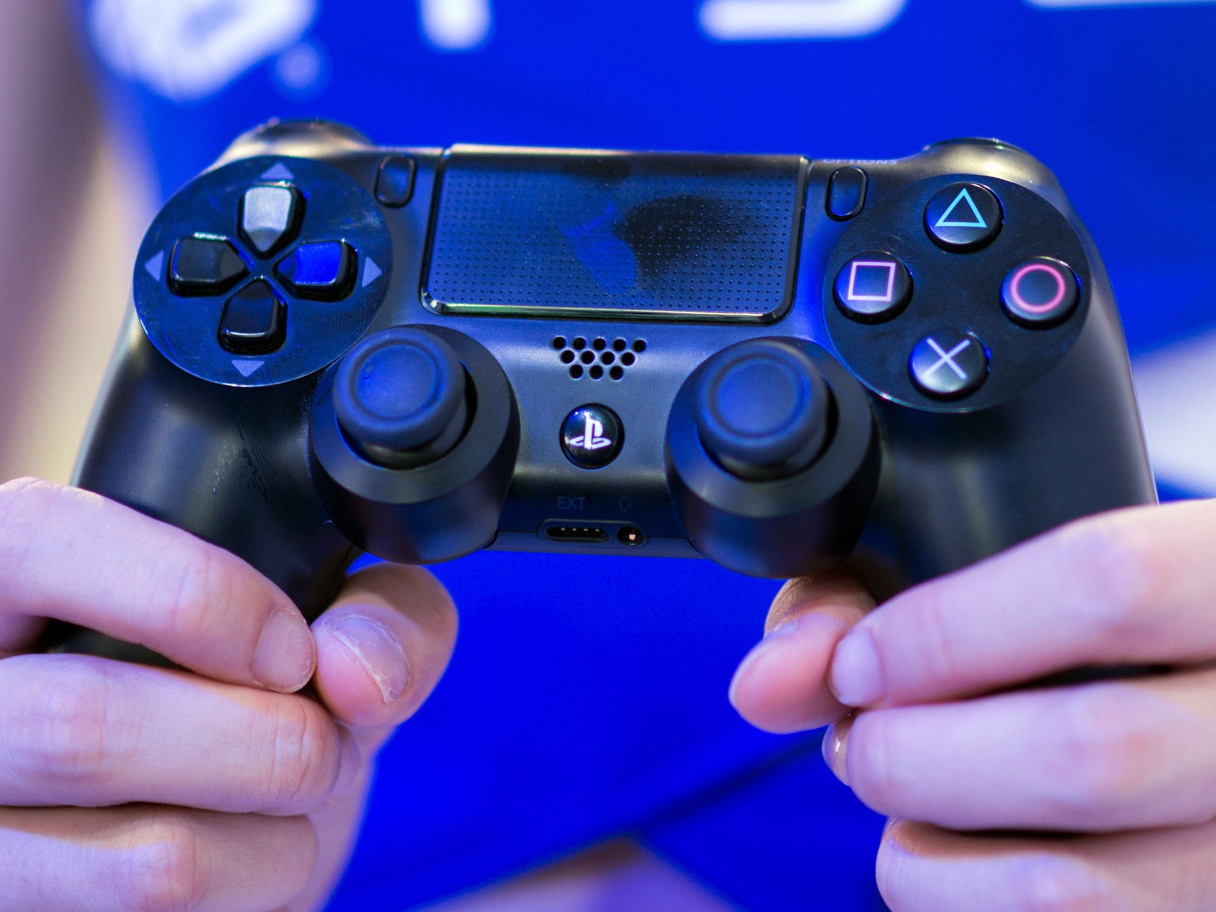 A PlayStation representative holds a PS4 controller