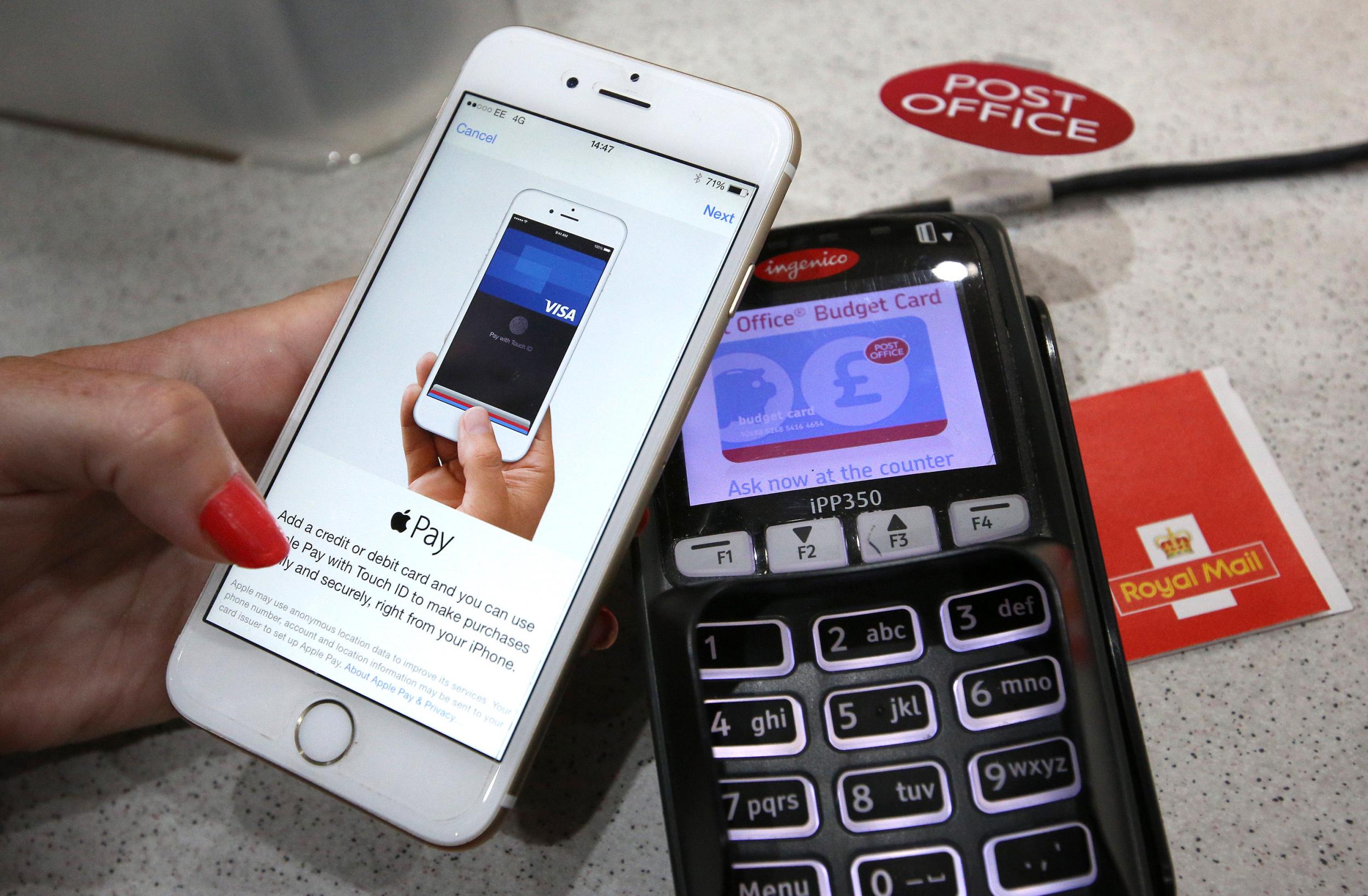 A woman uses Apple Pay at a Post Office