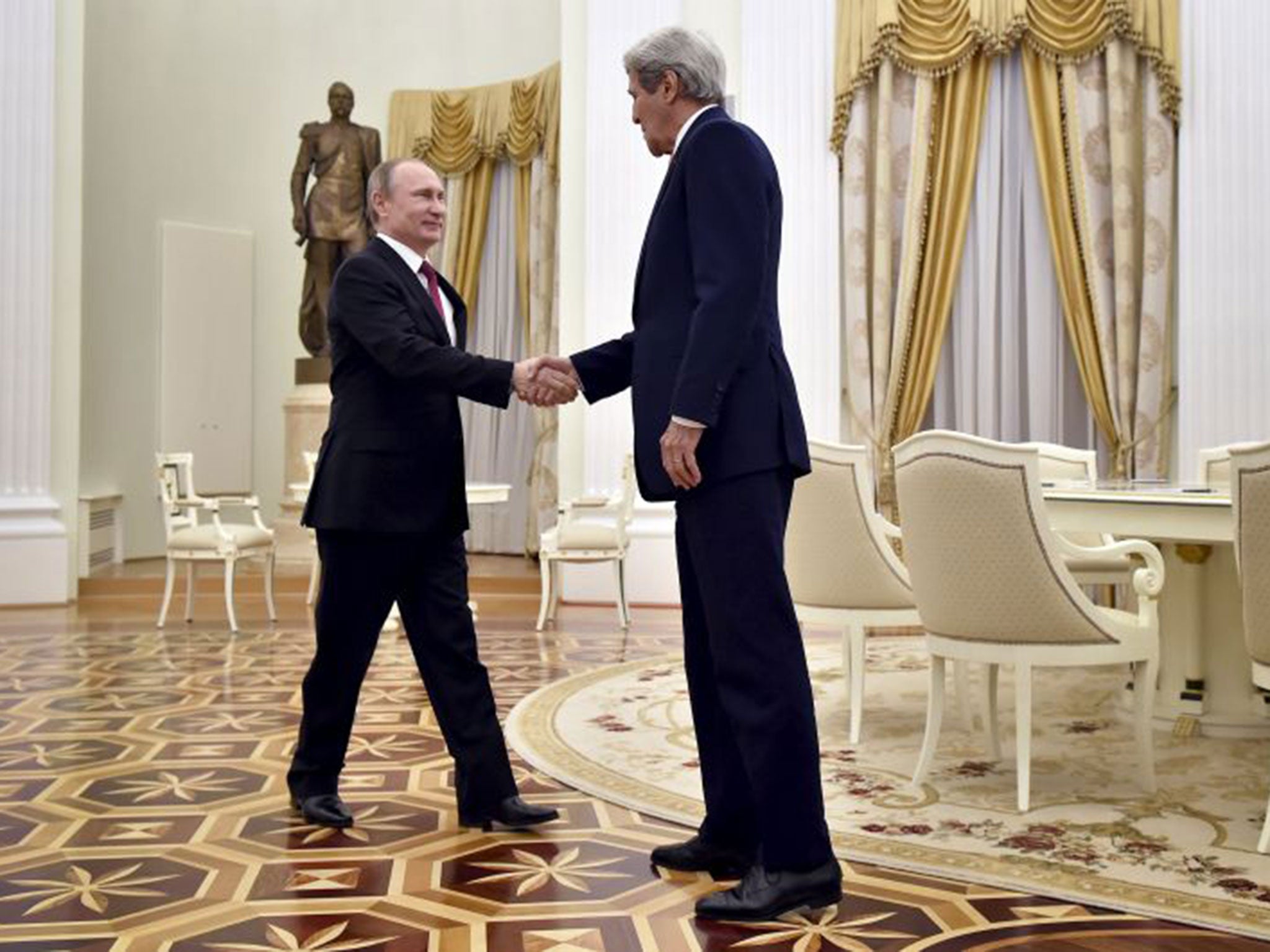 John Kerry shakes hands with Russian President Vladimir Putin during a meeting at the Kremlin in Moscow