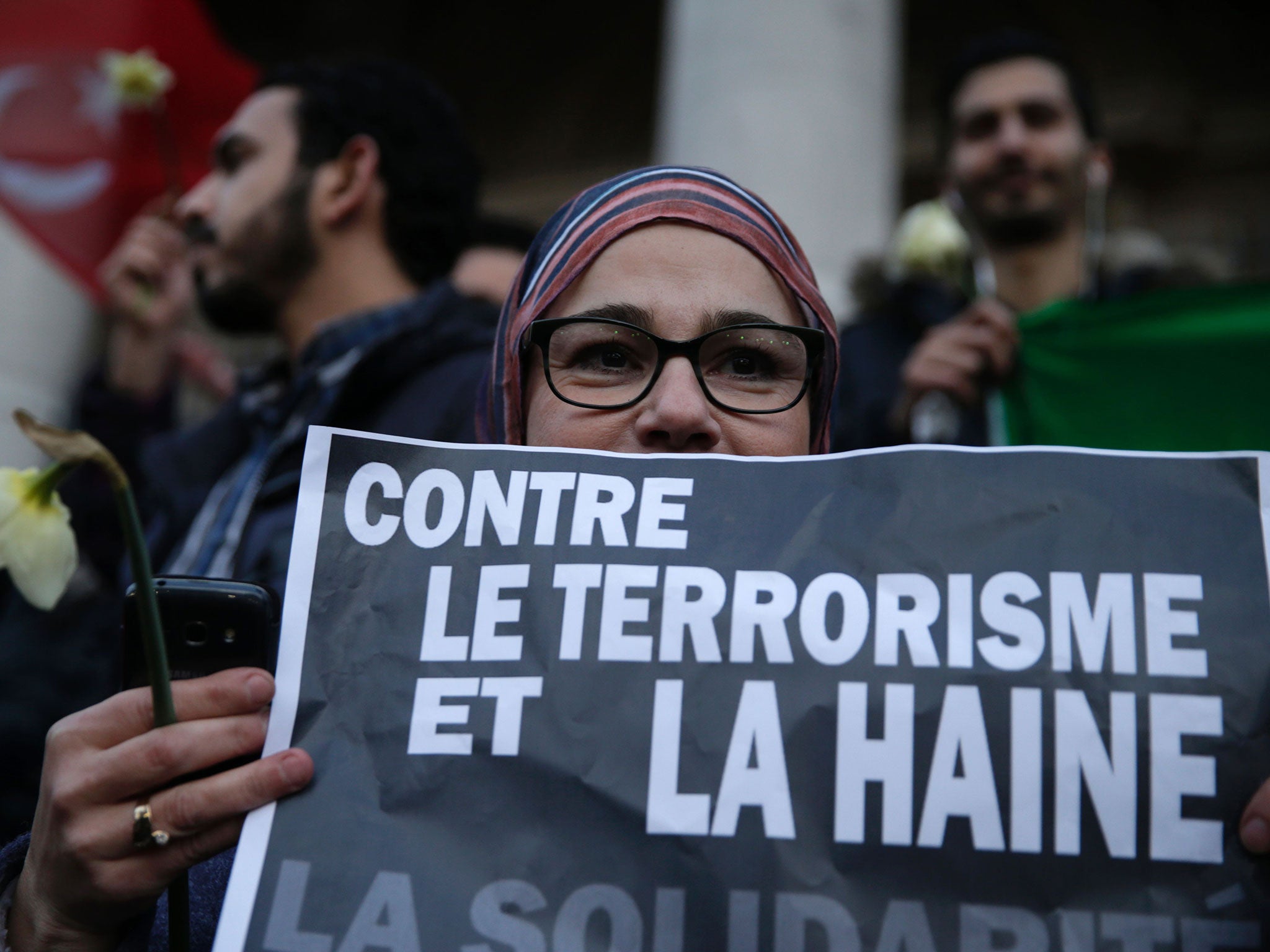 A woman holds a placard reading ‘Against terrorism and hatred, Solidarity’, at a makeshift memorial on the Place de la Bourse in Brussels. Responsibility for the attack has been claimed by Isis