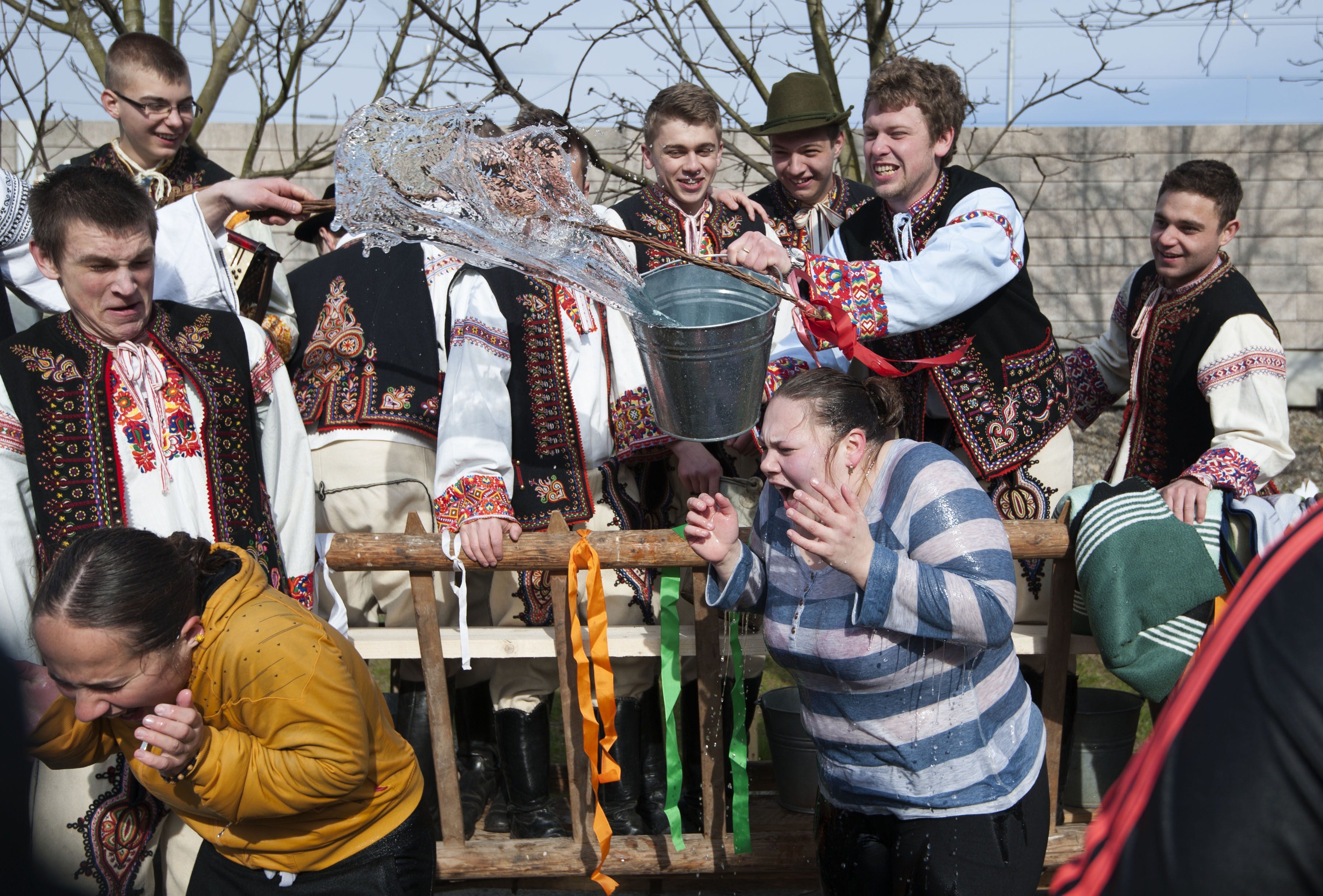 Dancers of 'Matyo Folklor Art Association' in traditional clothes, react as boys throw water in Mezokovesd, some 130 km east of Budapest.