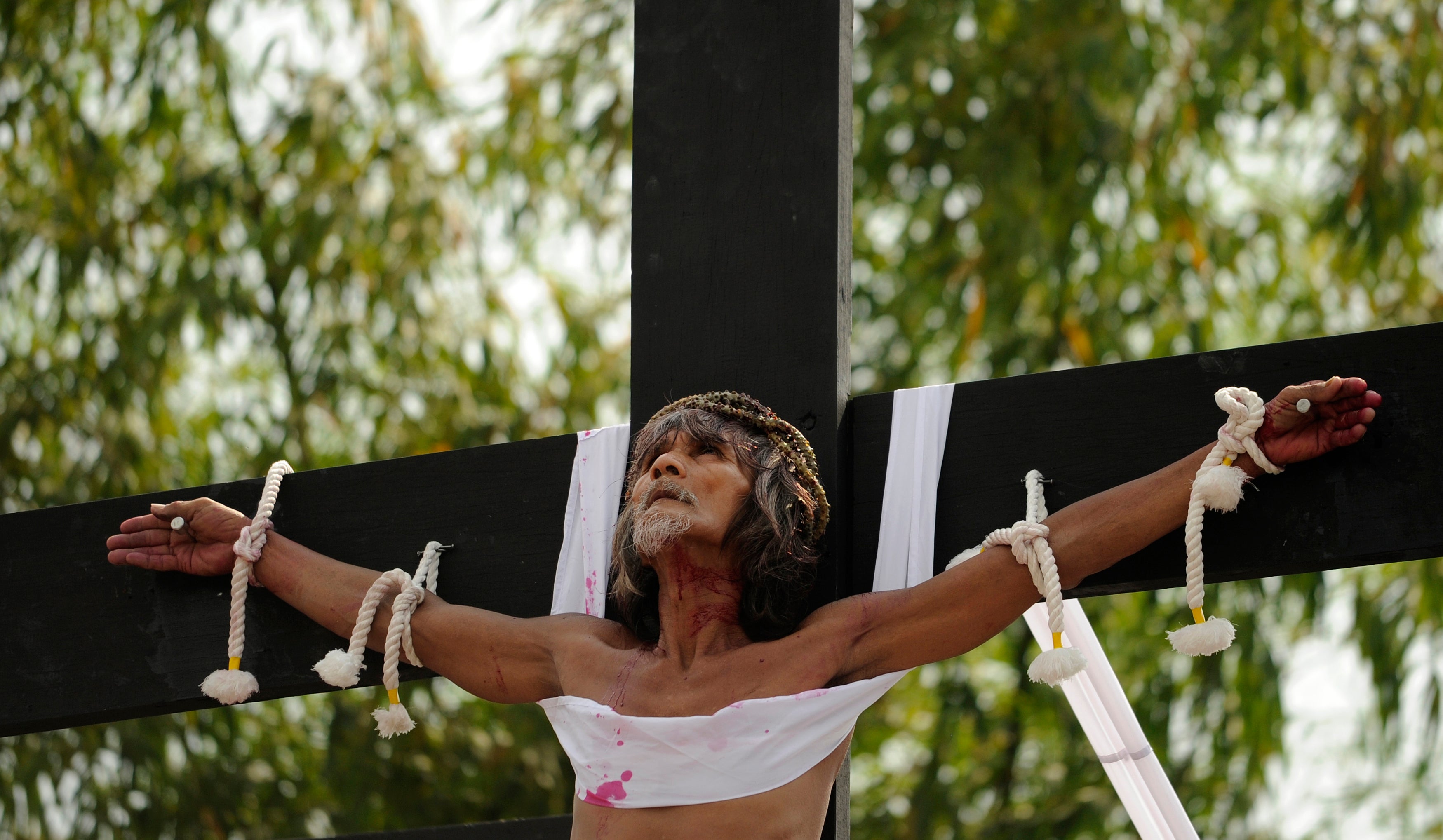 Willy Salvador, 59, hangs from a cross as part of his penitence during a reenactment of the crucifixion of Jesus Christ for Good Friday celebrations ahead of Easter in the village of San Juan, Pampanga
