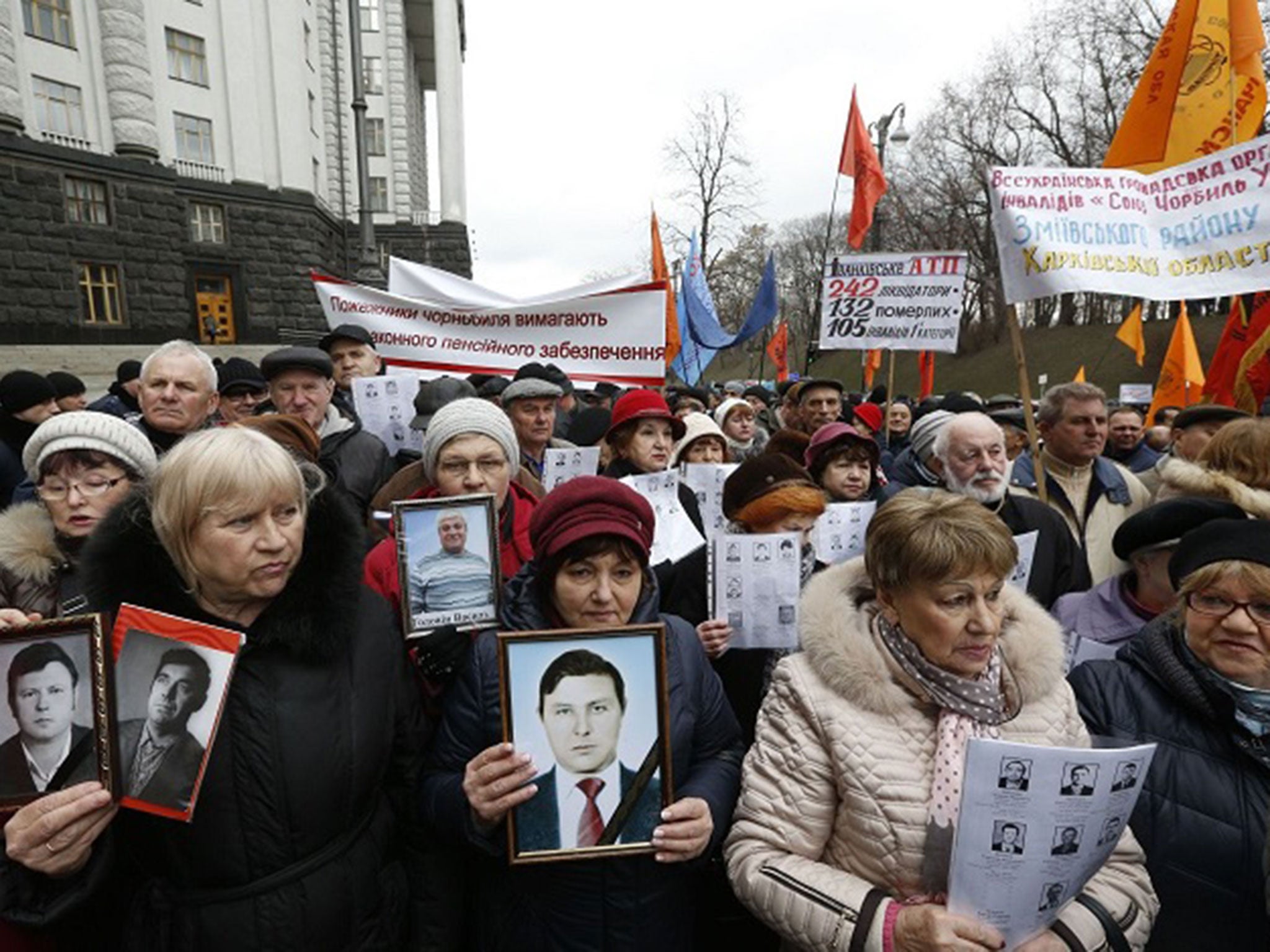 People hold photos of loved-ones who died during or as a result of the Chernobyl disaster during a protest rally in Kiev, Ukraine