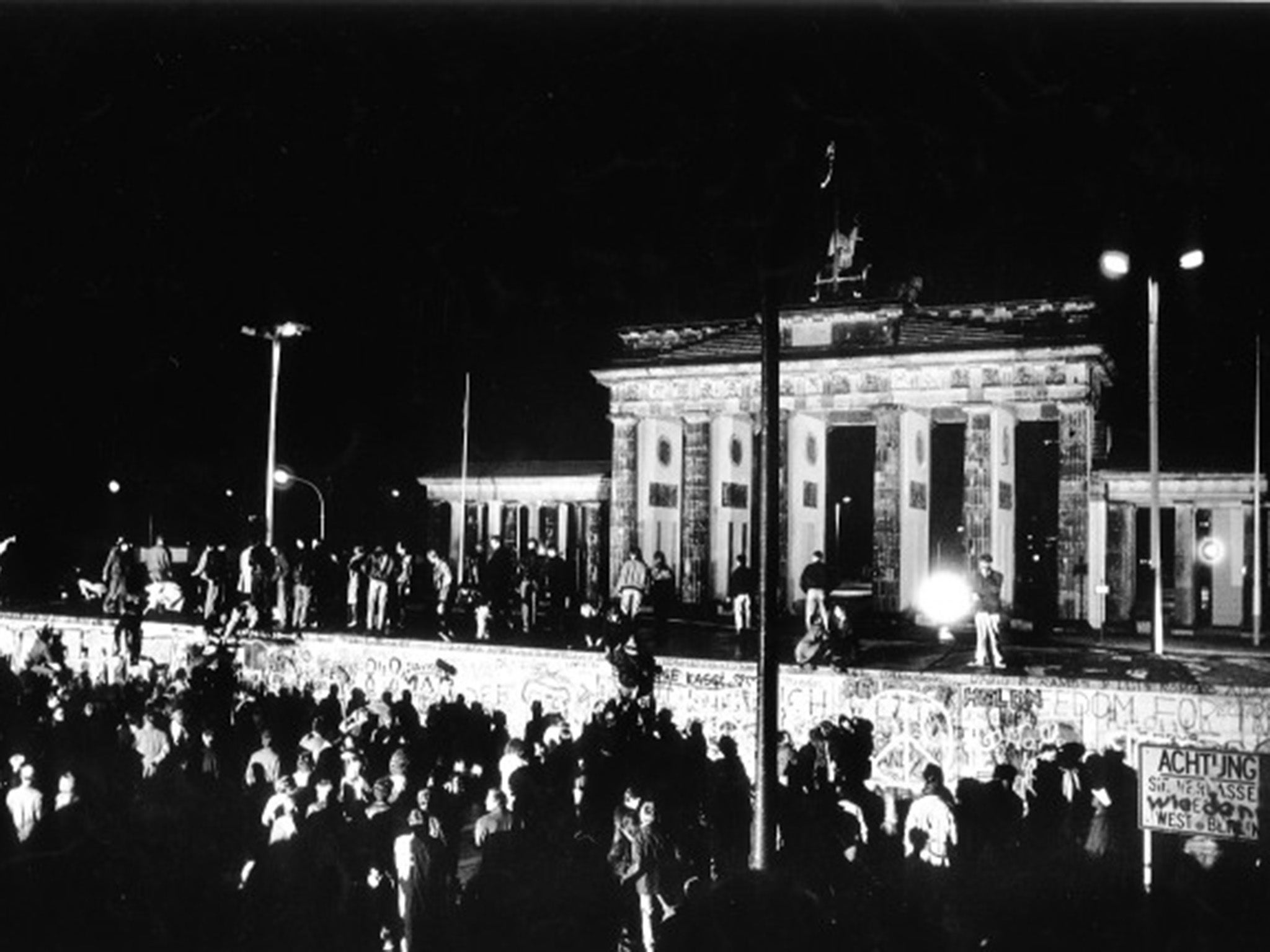 People at the Berlin Wall celebrate the collapse of communism in East Germany, in a picture taken by Brian Harris for ‘The Independent’ in November 1989