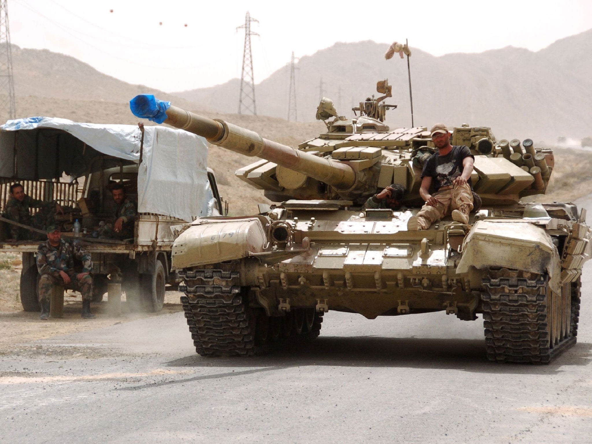 Syrian pro-government forces drive a tank on the outskirts of Palmyra during a military operation to retake the ancient city from Isis