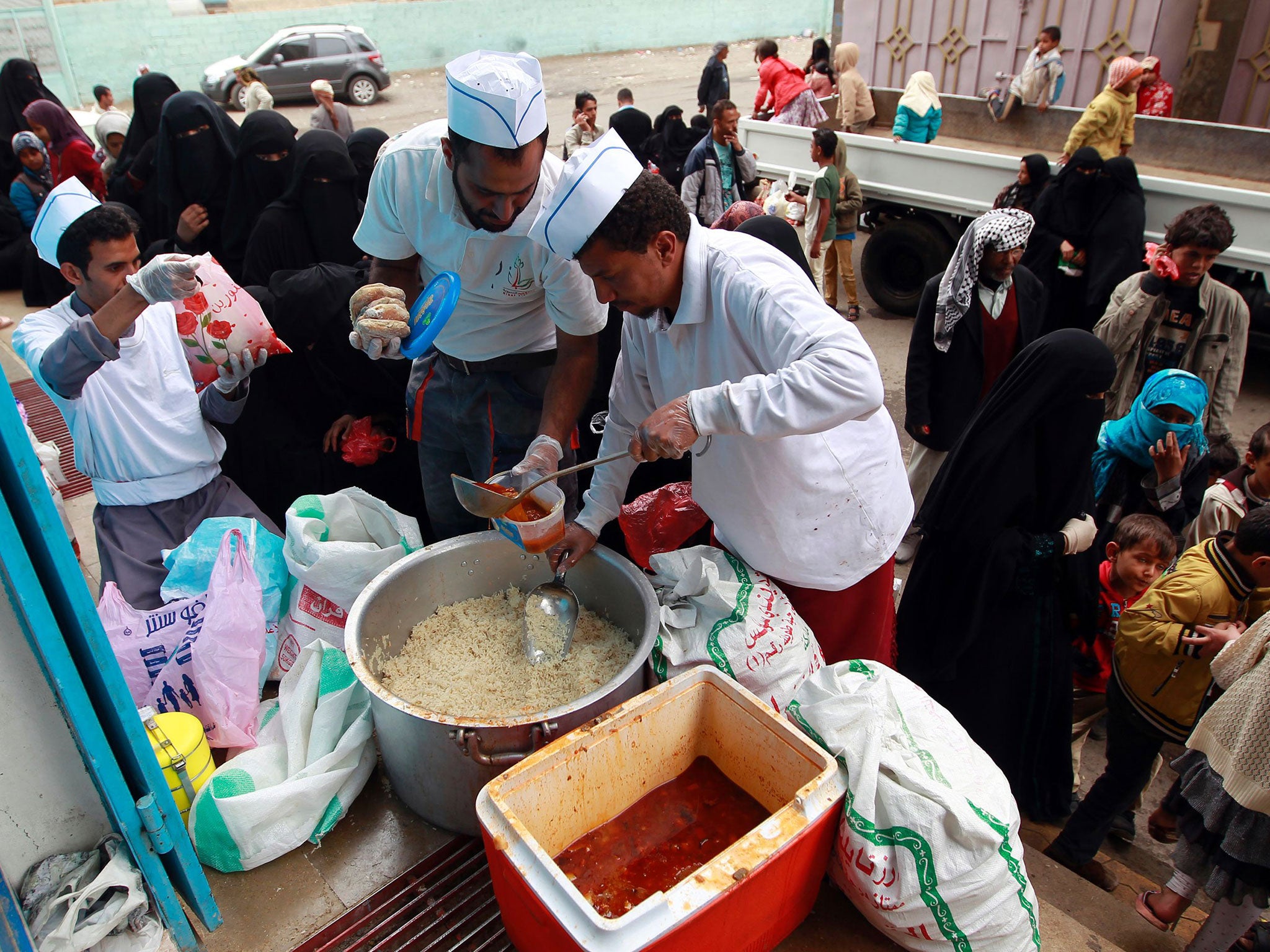 Yemeni volunteers distribute food to poor families in the capital Sanaa