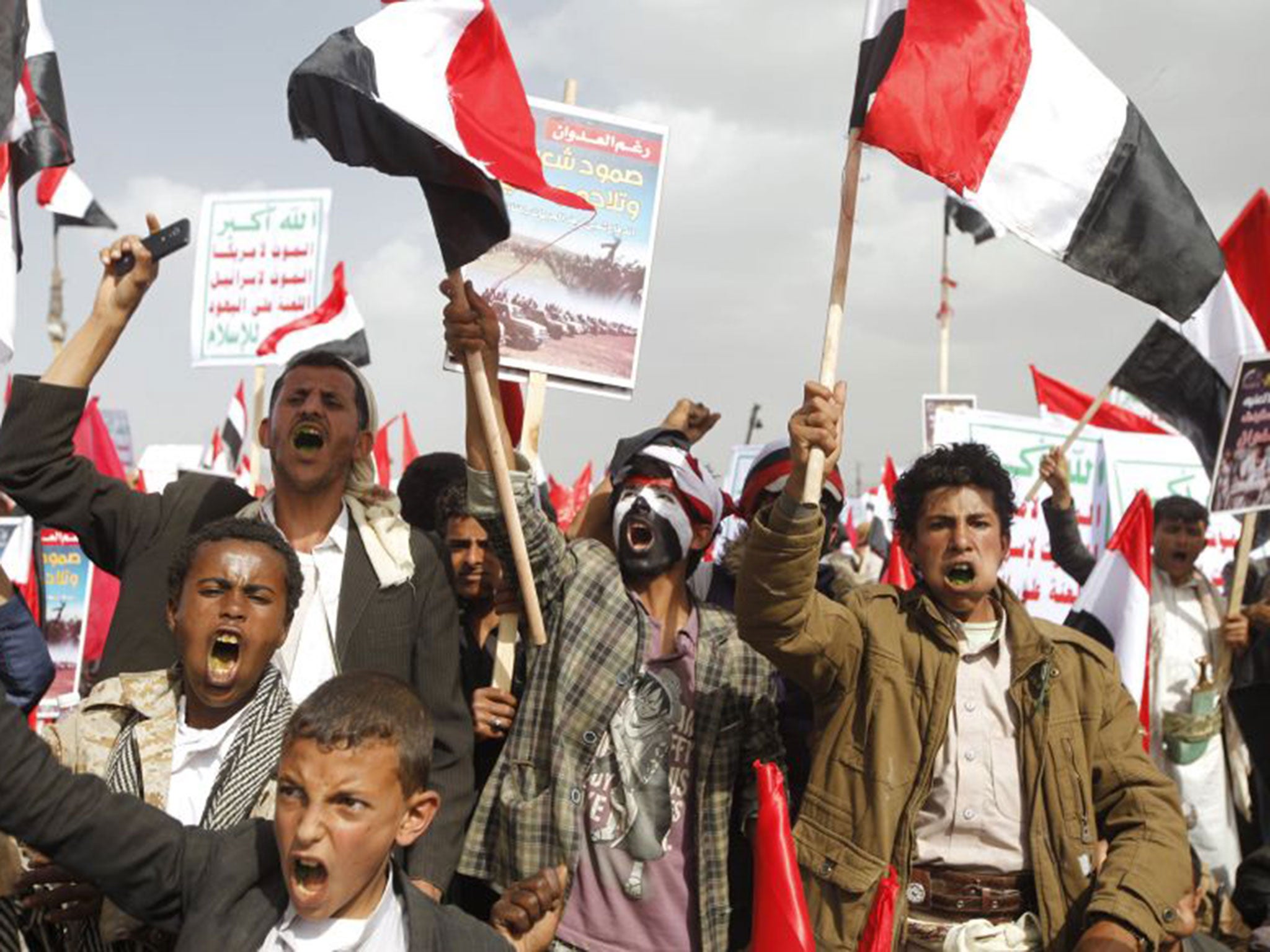 Houthis attend a rally in Sanaa to mark a year of Saudi-led air strikes