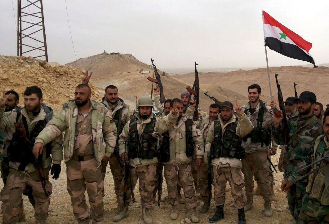 Troops loyal to Bashar al-Assad celebrate on the edge of Palmyra