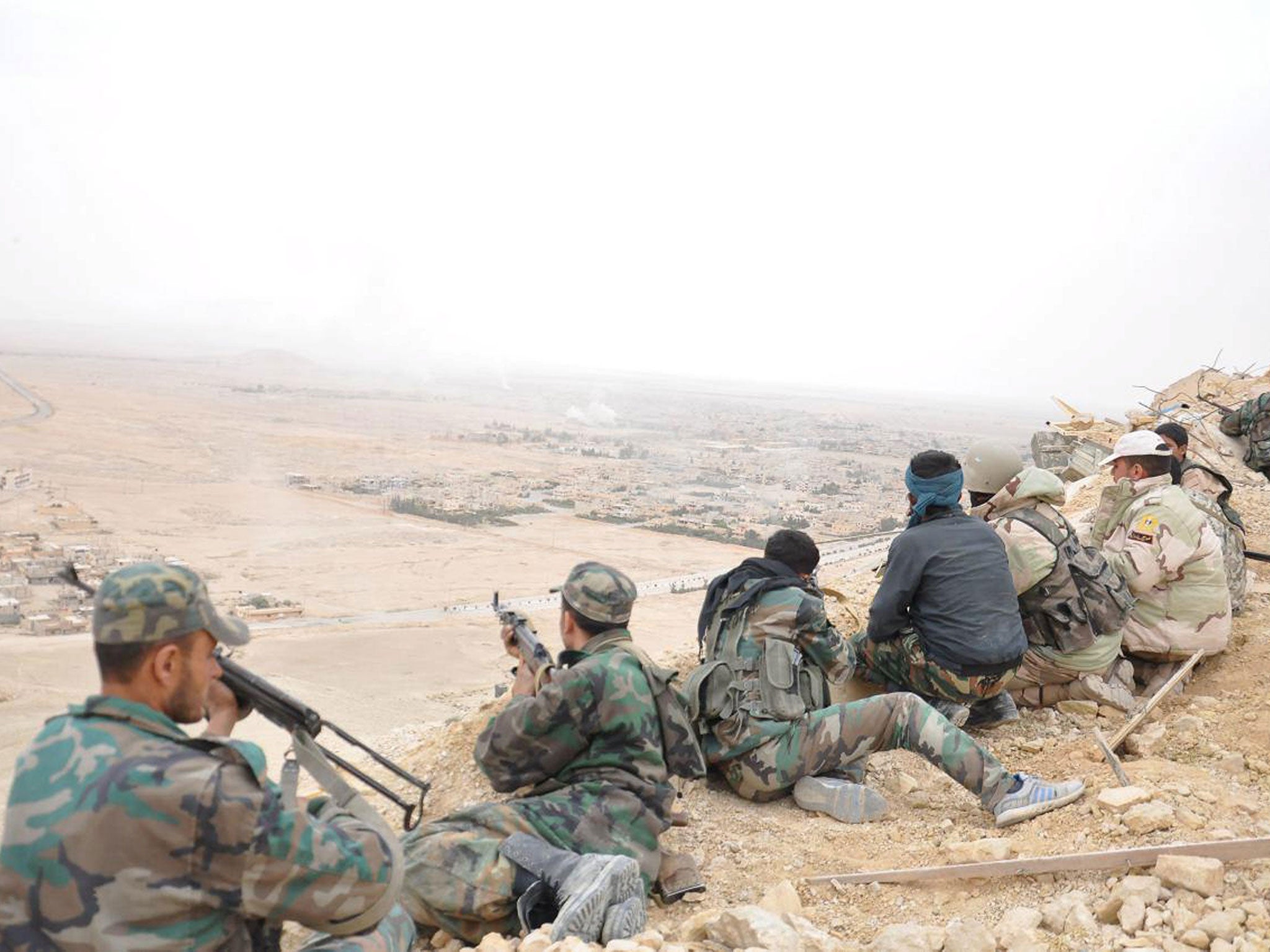 Forces loyal to Syria's President Bashar al-Assad take positions on a look-out point overlooking the historic city of Palmyra