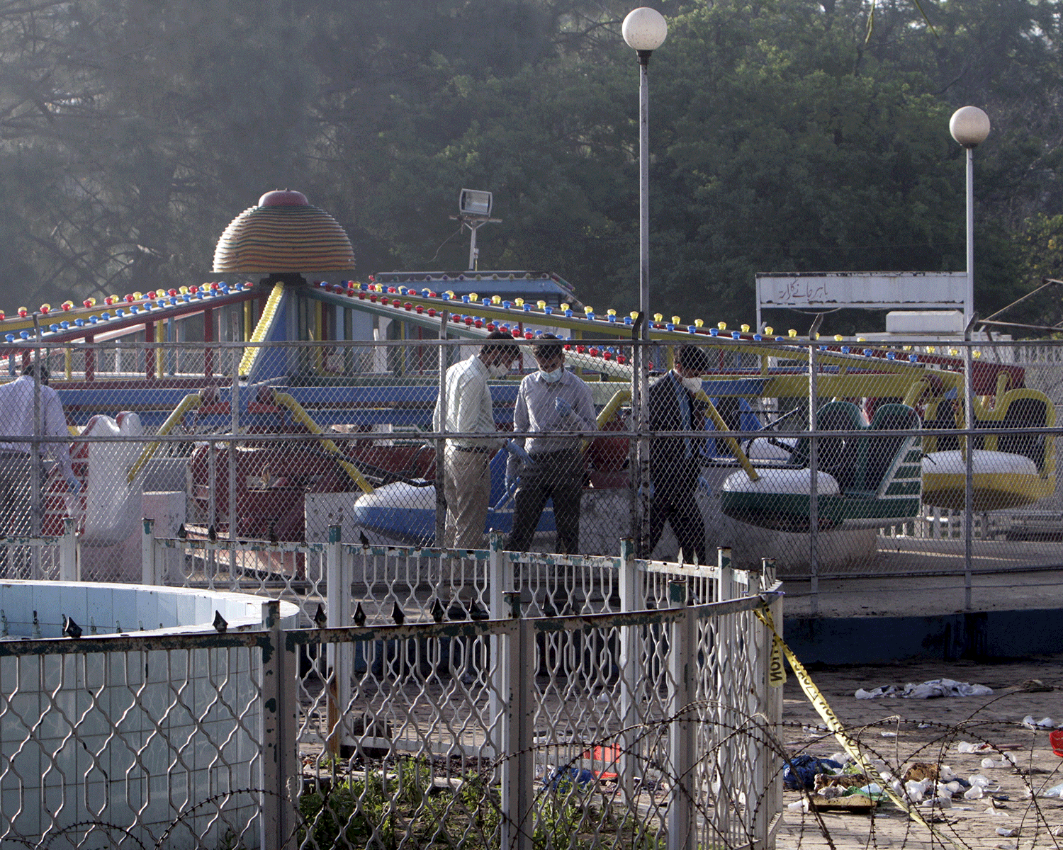 Forensic officers look for evidence at the site of a blast that happened outside a public park on Sunday, in Lahore, Pakistan, March 28, 2016