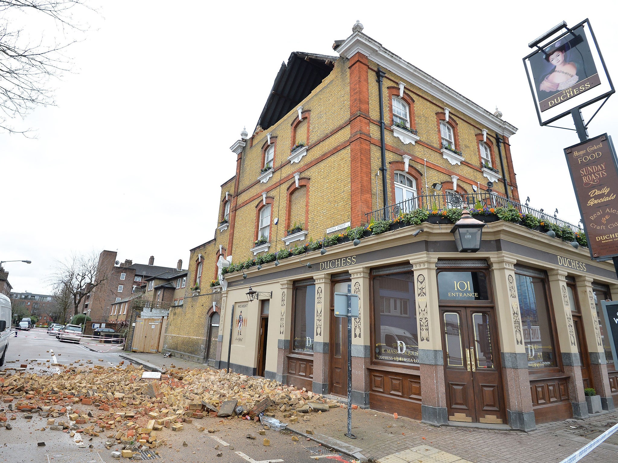 Rubble strewn across the road outside The Duchess public house in Battersea, south west London