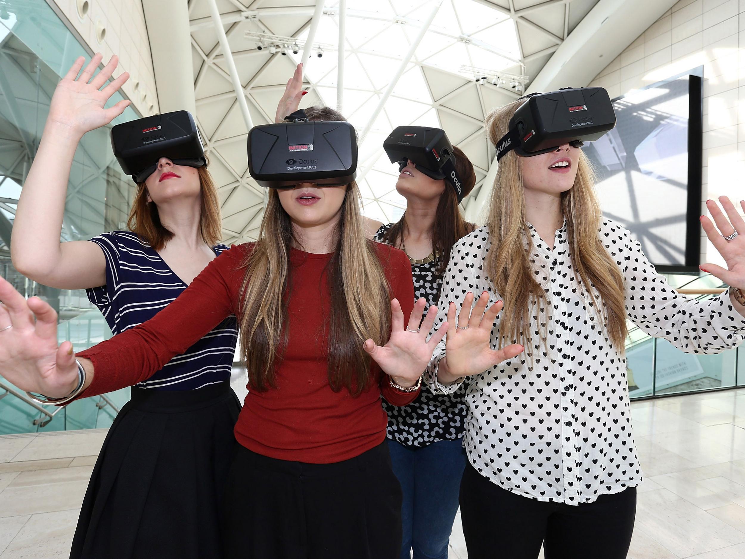 Women use the Oculus Rift DK2 at the Westfield Shopping Centre in London